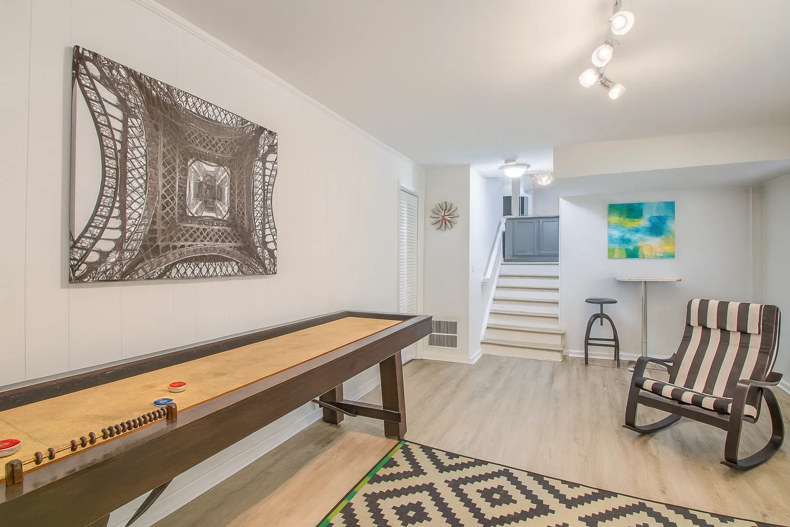 Modern family-friendly game room with shuffleboard table and contemporary furniture in Charlotte vacation rental