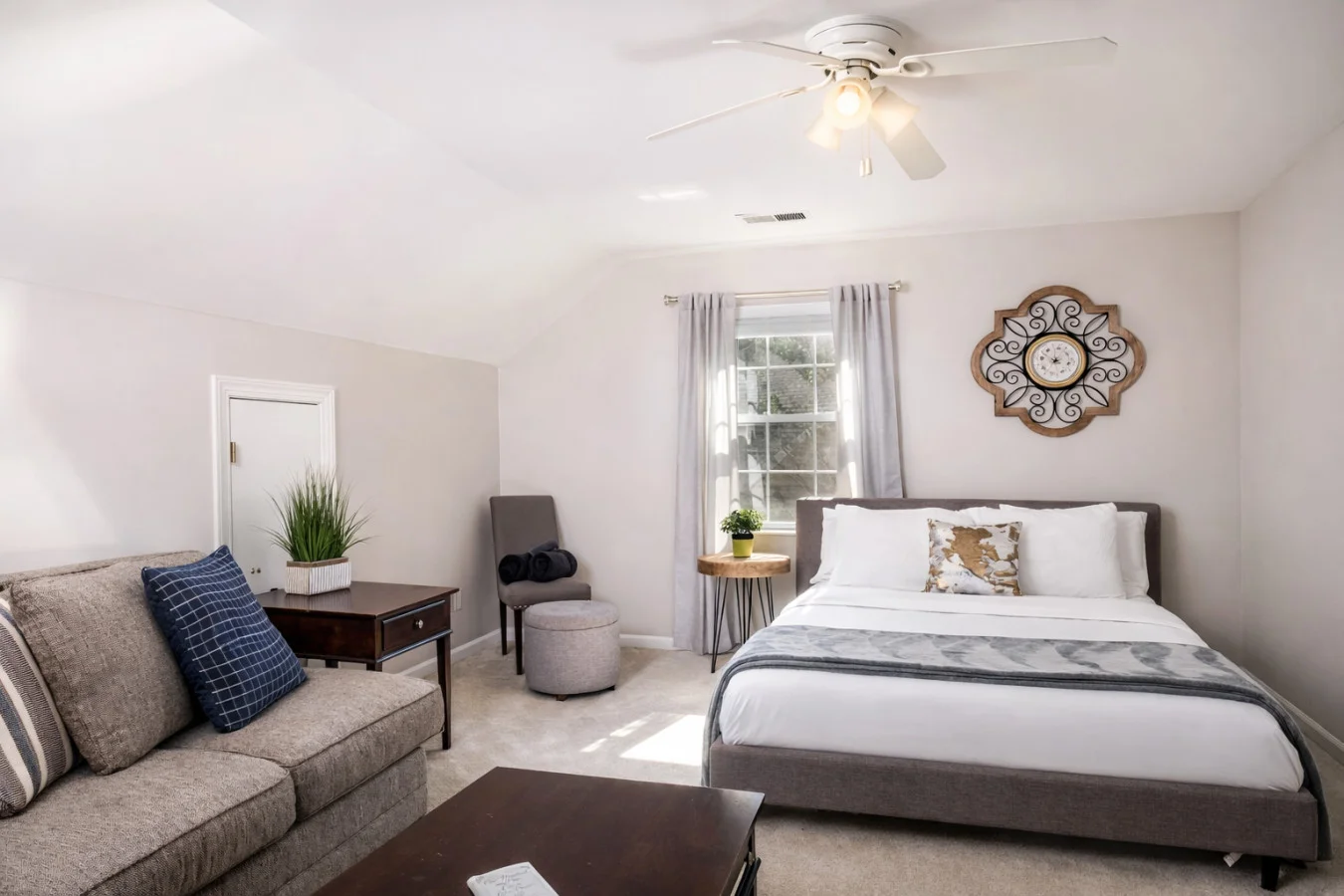Spacious master bedroom with king bed and gray sofa in Charlotte's Suburban Sanctuary Retreat. Best Pizza in Charlotte: 10 Spots That Earn the Hype in 2026