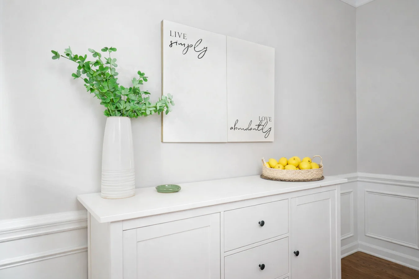 White entryway console with green plant, lemons, and minimalist decor in Charlotte, NC