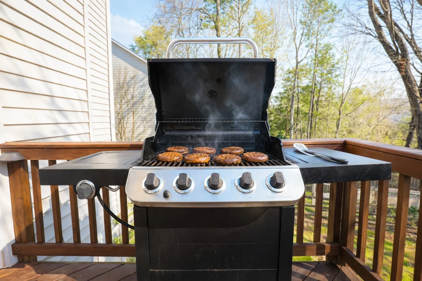 Gas grill with burgers on wooden deck with wooded views in Charlotte NC Charlotte NC's Number One Attraction