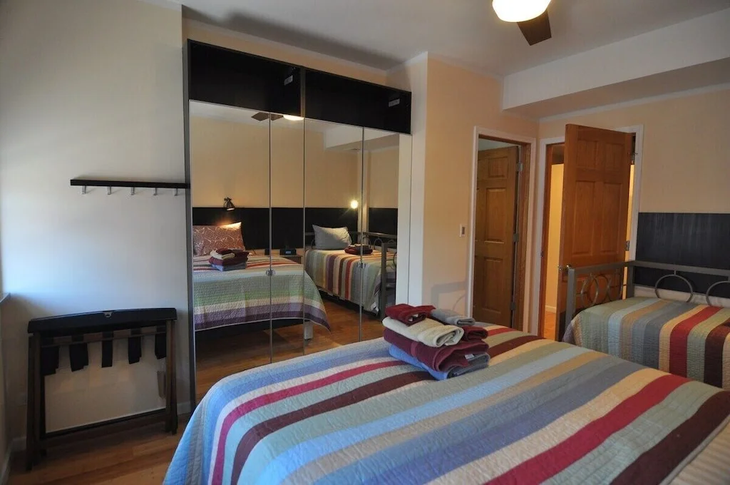 Modern bedroom with multiple beds and mirrored closet in Chicago vacation rental