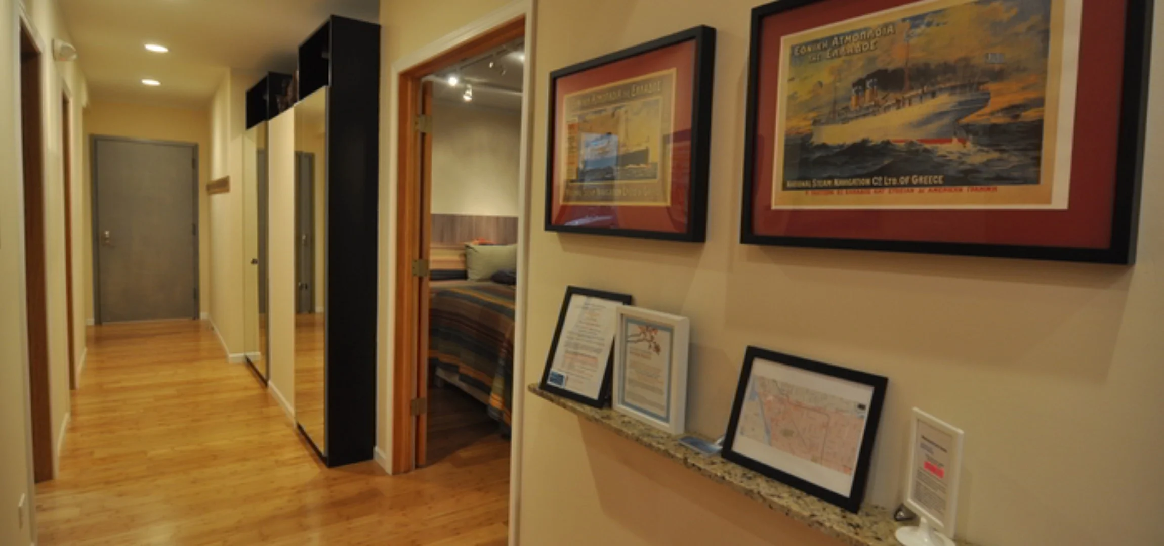 Group dinner space for a Chicago bachelorette weekend: entrance hallway with hardwood floors, framed vintage Greek travel