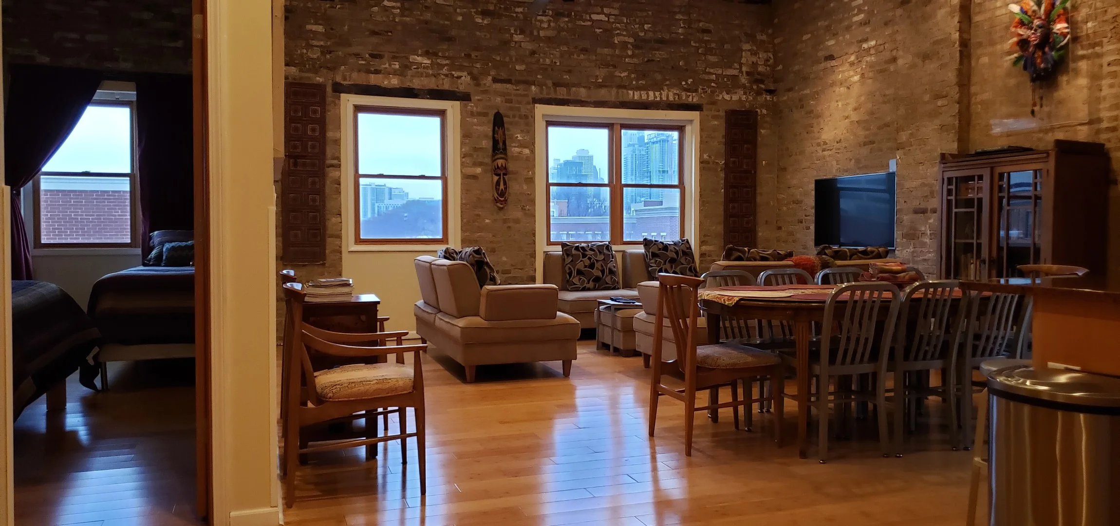 Open-concept loft living area with exposed brick walls and city skyline views in Lincoln Park Chicago