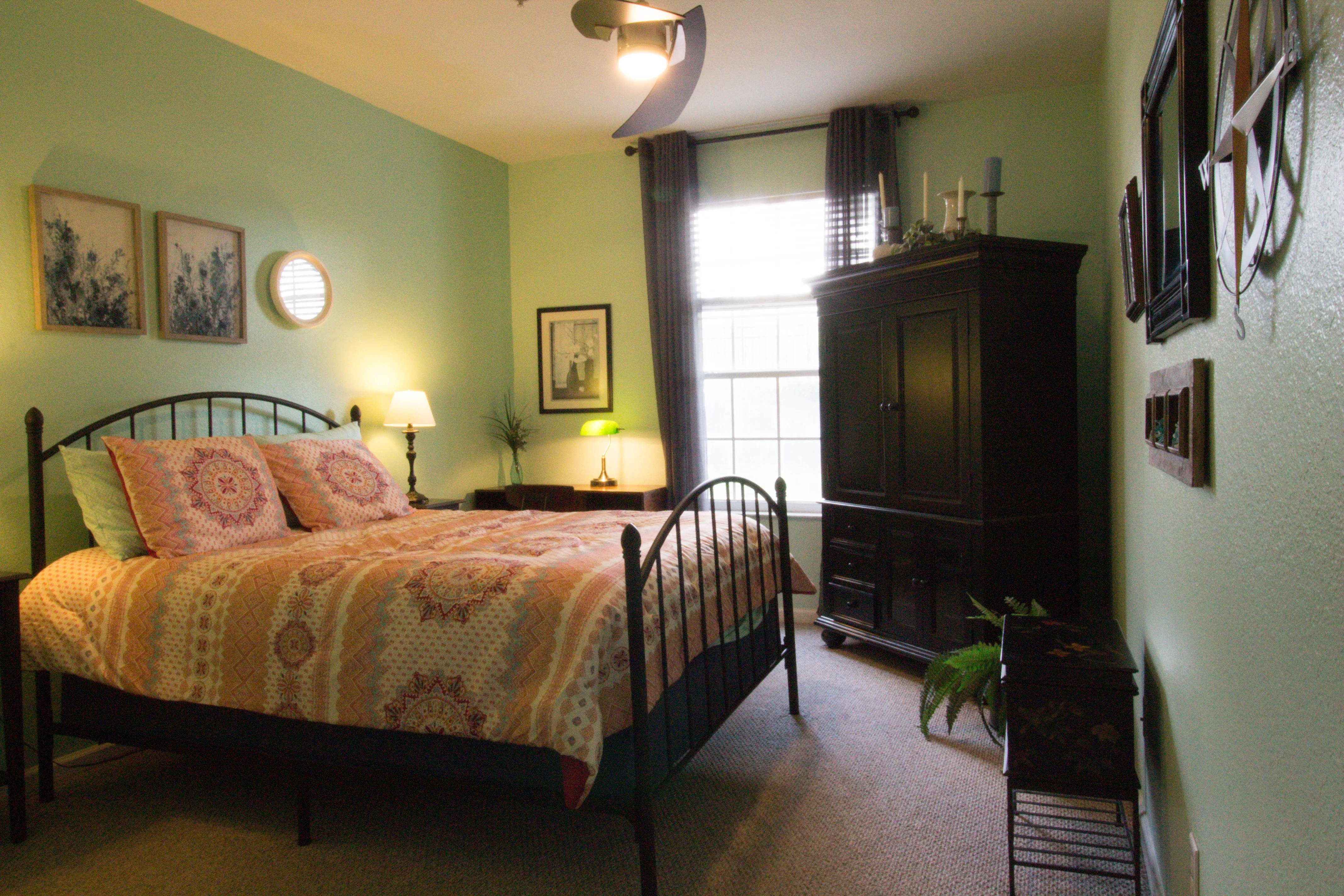 Cozy bedroom with green walls, wrought iron bed, and traditional decor at Stay Formosa Orlando villa