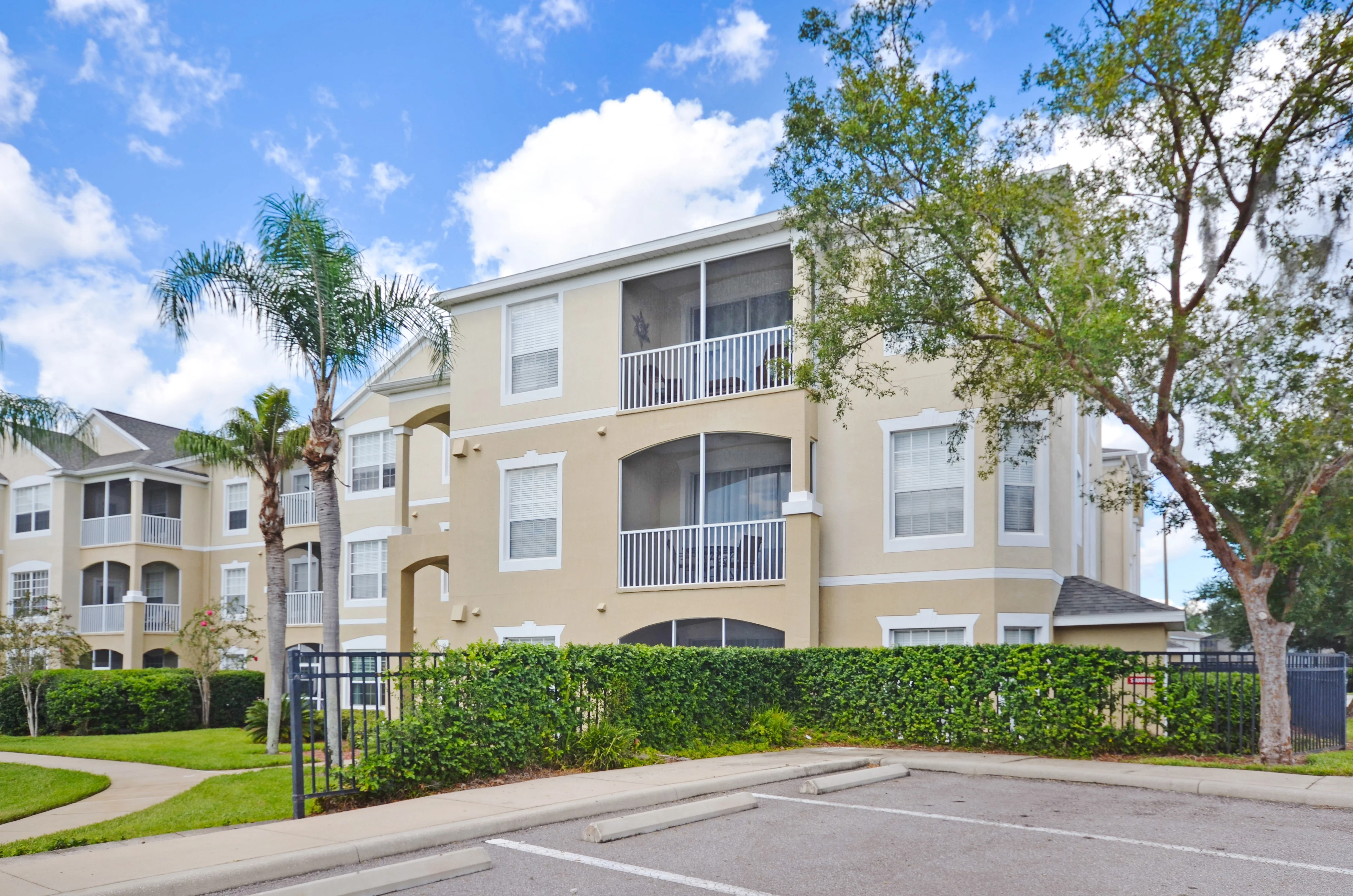 Modern apartment building exterior with palm trees and balconies near Davenport FL vacation rentals
