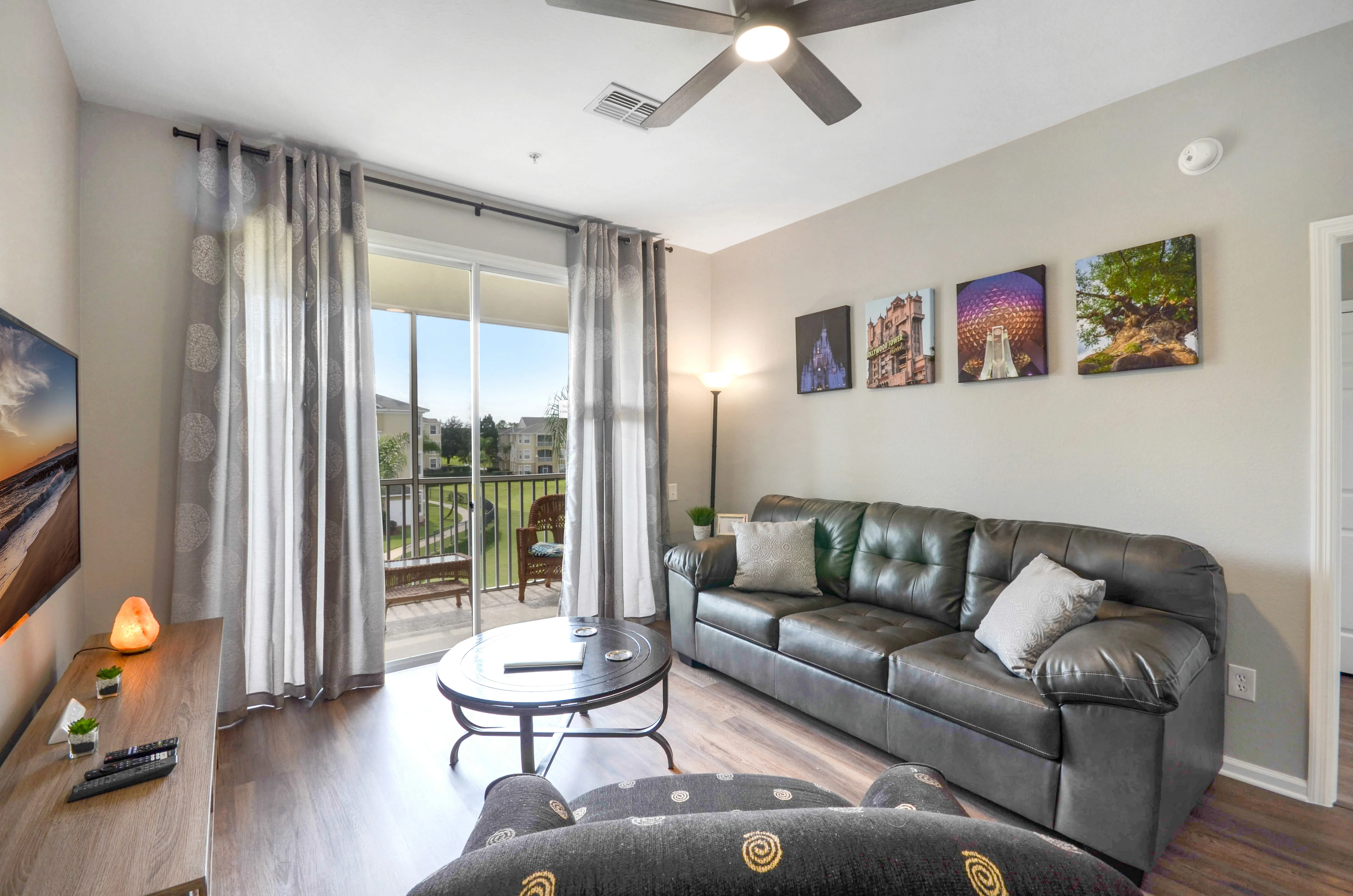 Modern living room with gray leather sectional and balcony view in Davenport FL vacation rental