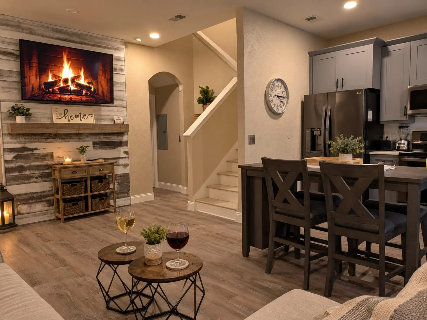 Modern living room with fireplace, wood accent wall, dining table, and open kitchen
