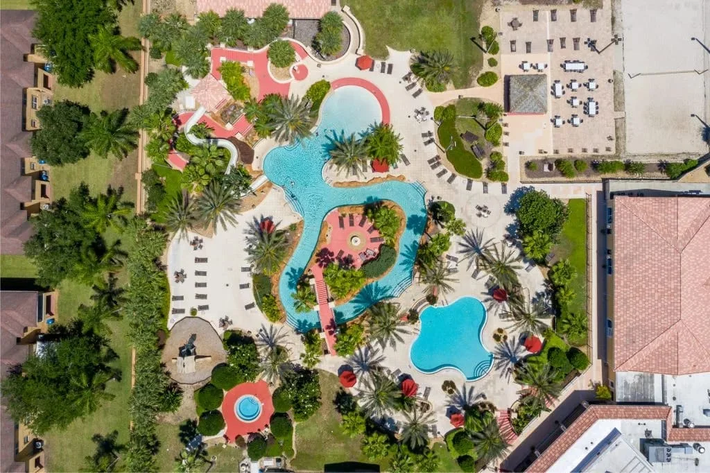 Aerial view of resort pool complex with turquoise water and tropical landscaping near Orlando Florida