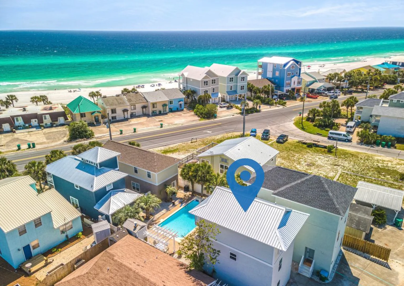 Modern white three-story coastal home with palm trees and Gulf views in Panama City Beach FL vacation rental