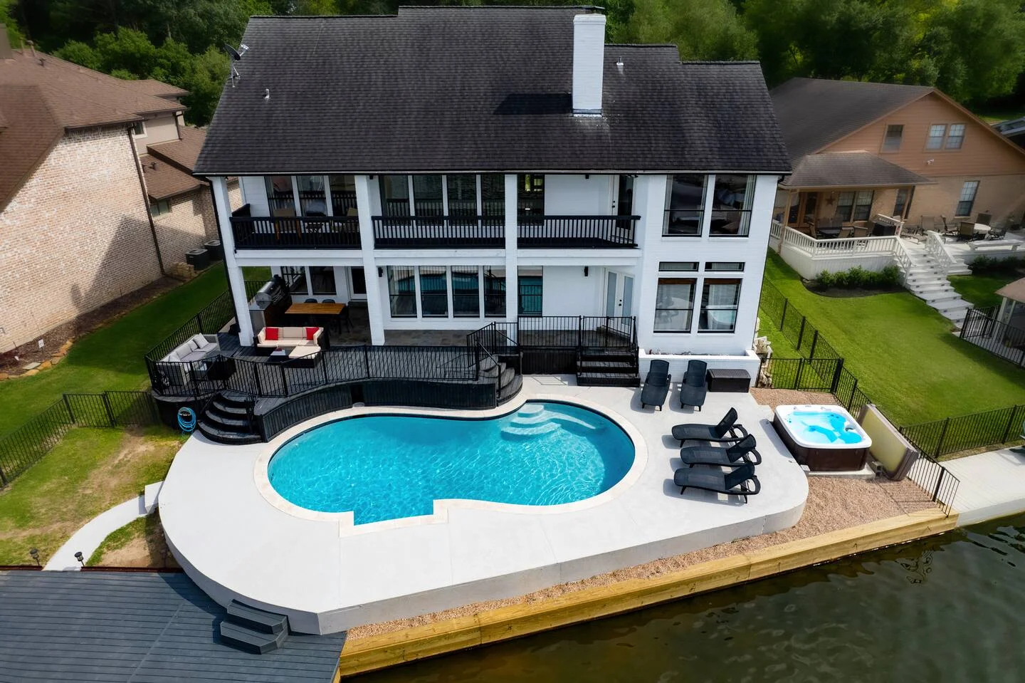 Aerial view of waterfront vacation rental with pool and hot tub overlooking Lake Conroe in Montgomery, TX