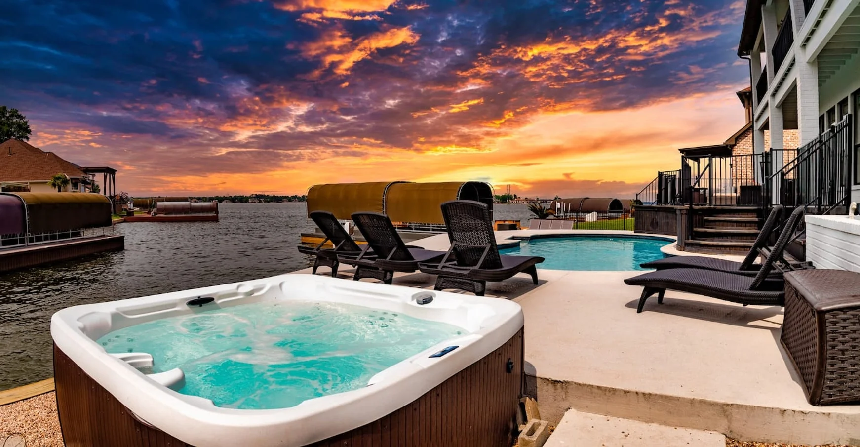 Waterfront patio with pool, hot tub, and private dock access at sunset in Montgomery, TX