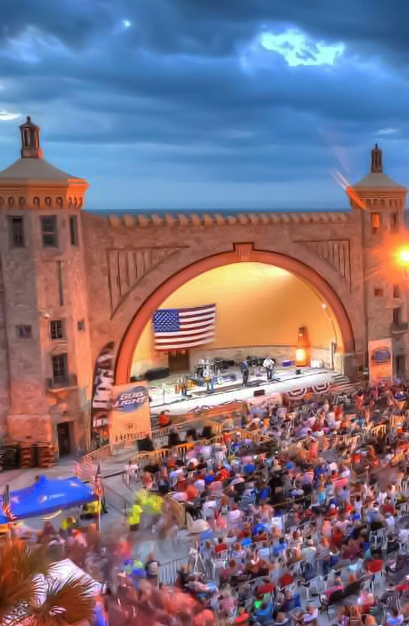 Outdoor event venue with copper-domed stage structure and crowds near ocean in Daytona Beach