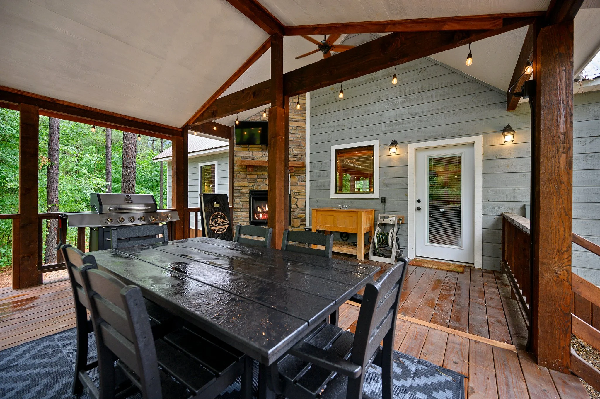 Covered patio with stone fireplace and grill, a cabin stay for visiting Broken Bow, OK