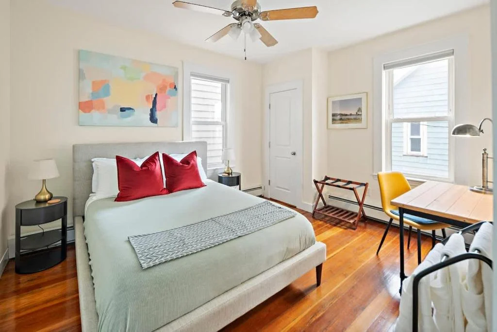Bright bedroom with hardwood floors and mid-century desk ideal for dynamic pricing management in Cambridge