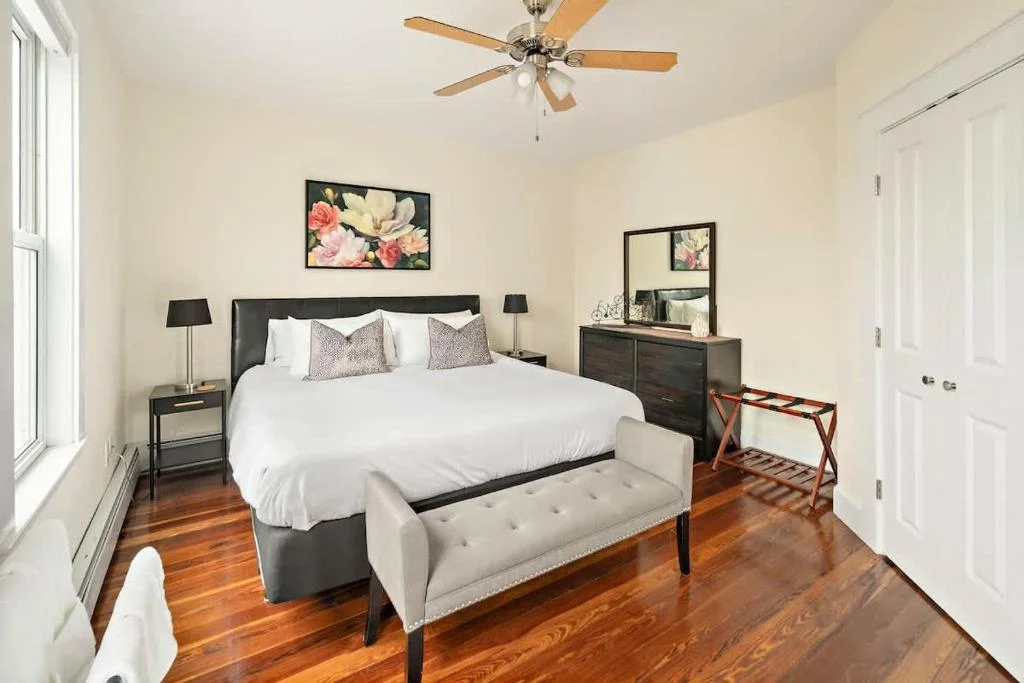 Master bedroom with queen bed and fresh white linens prepared for Cambridge short-term rental turnover