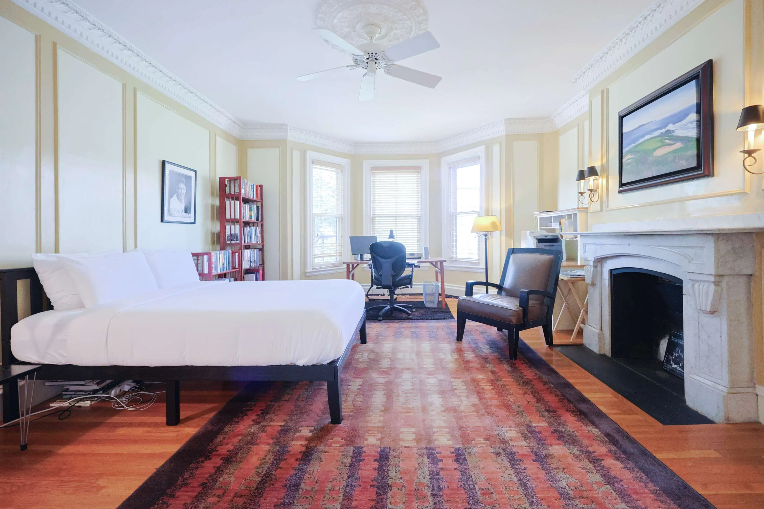 Luxury king bedroom with marble fireplace and bay windows in Boston row house rental
