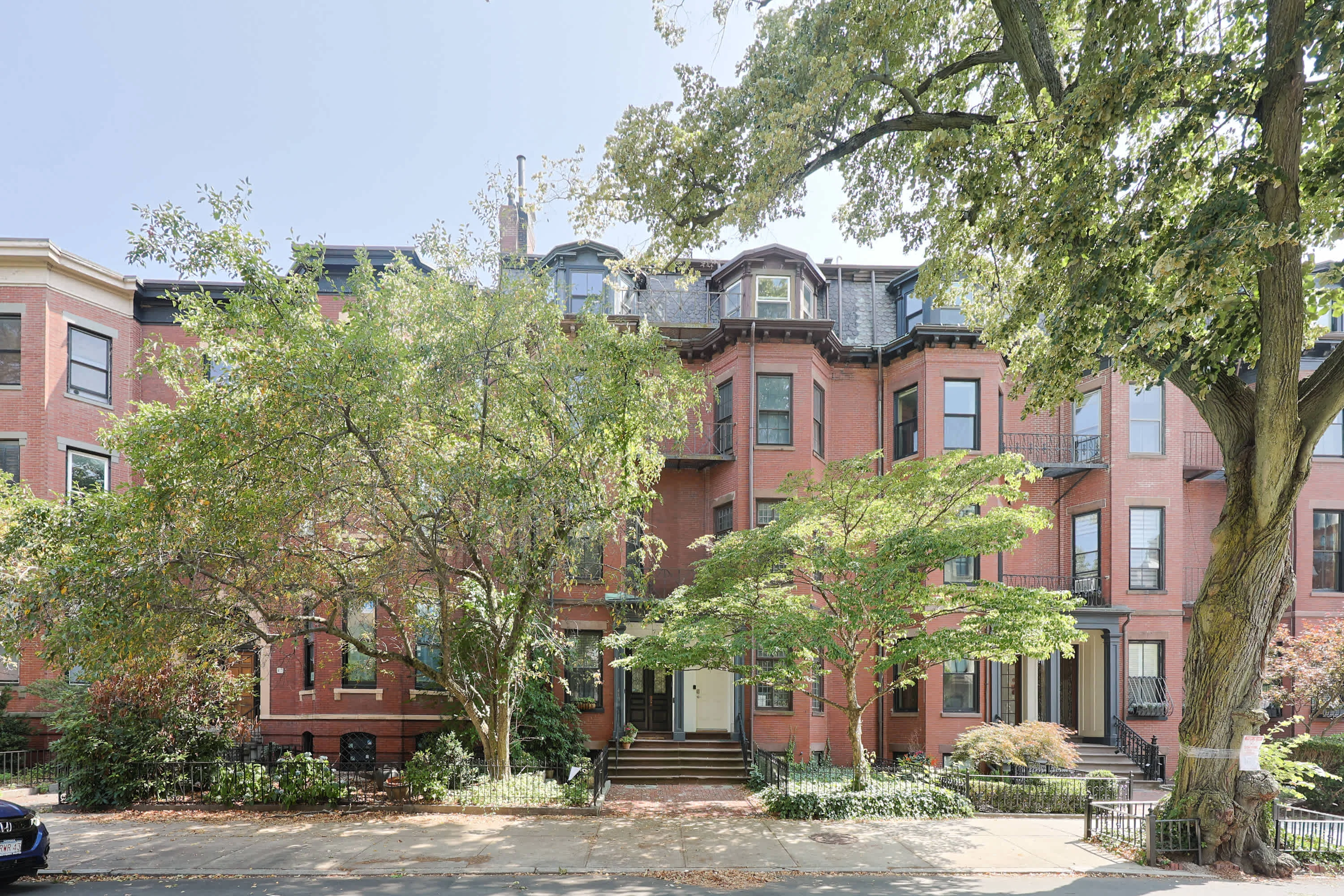 Historic Boston brownstone exterior with red brick, mansard roof, and tall windows on a Beacon Hill morning in our Boston