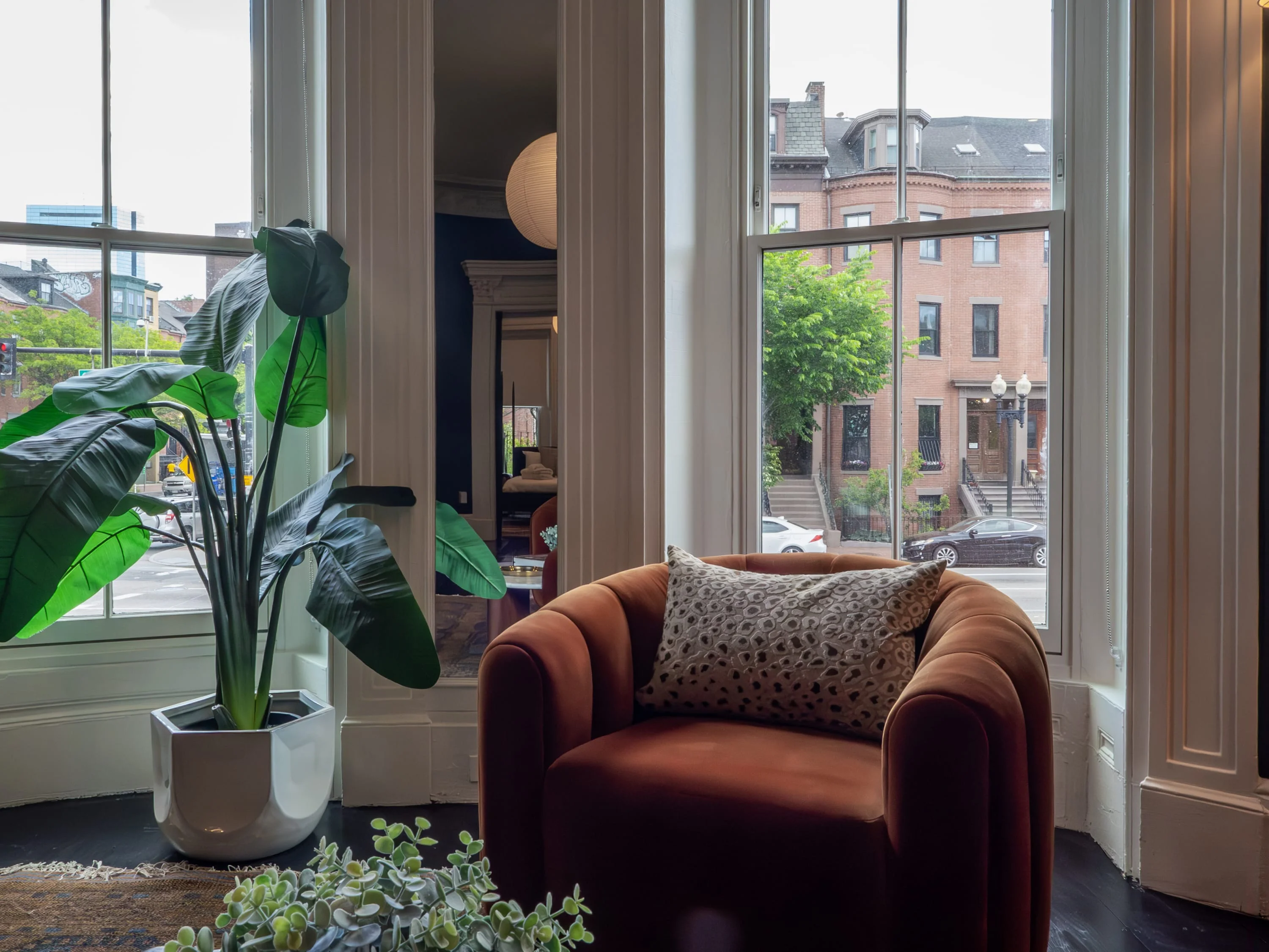 Modern penthouse living room with velvet armchair and Boston street views in The Chester