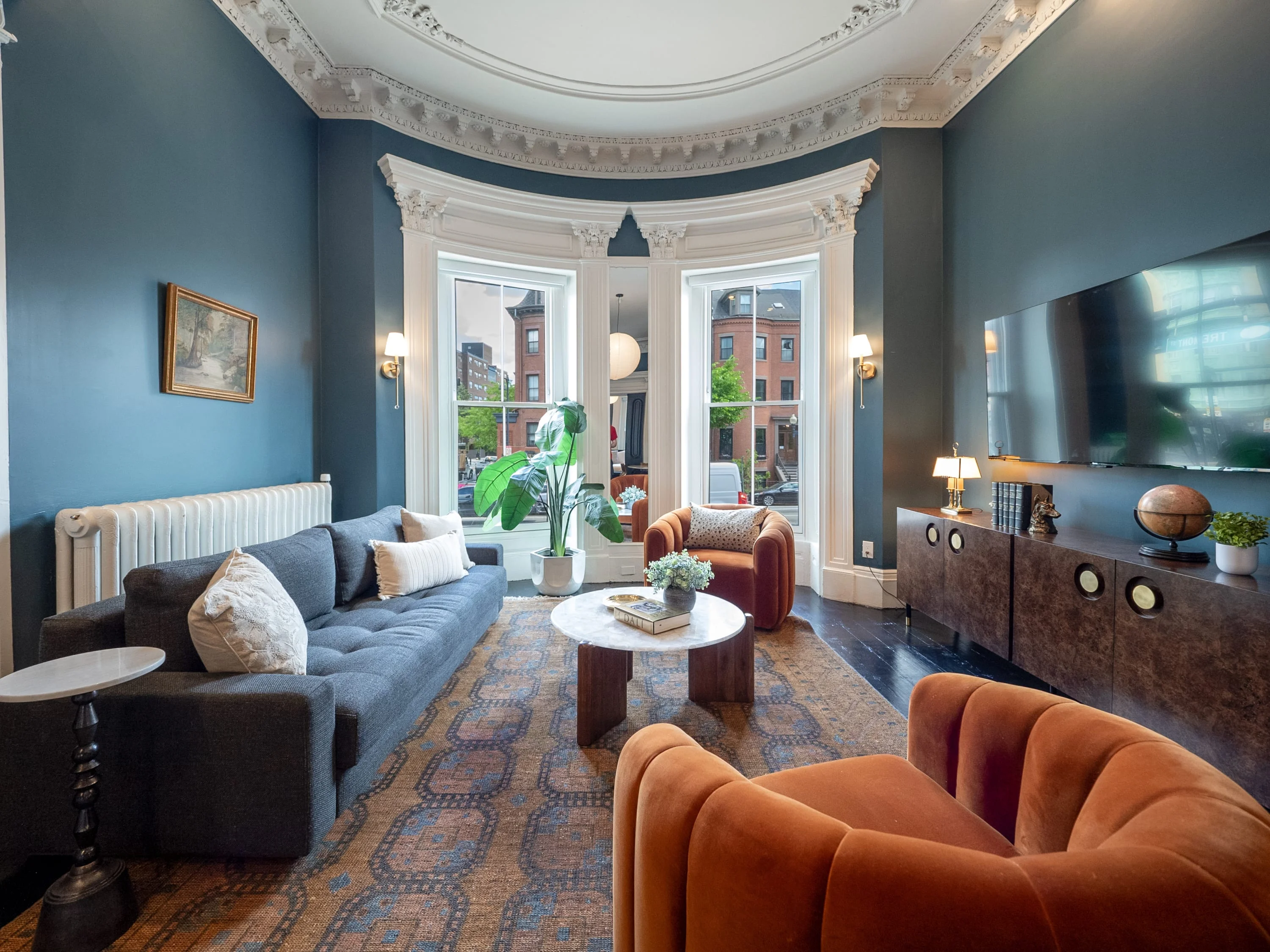 Penthouse living room with bay windows at a South End Hospitality Boston stay, near Cambridge