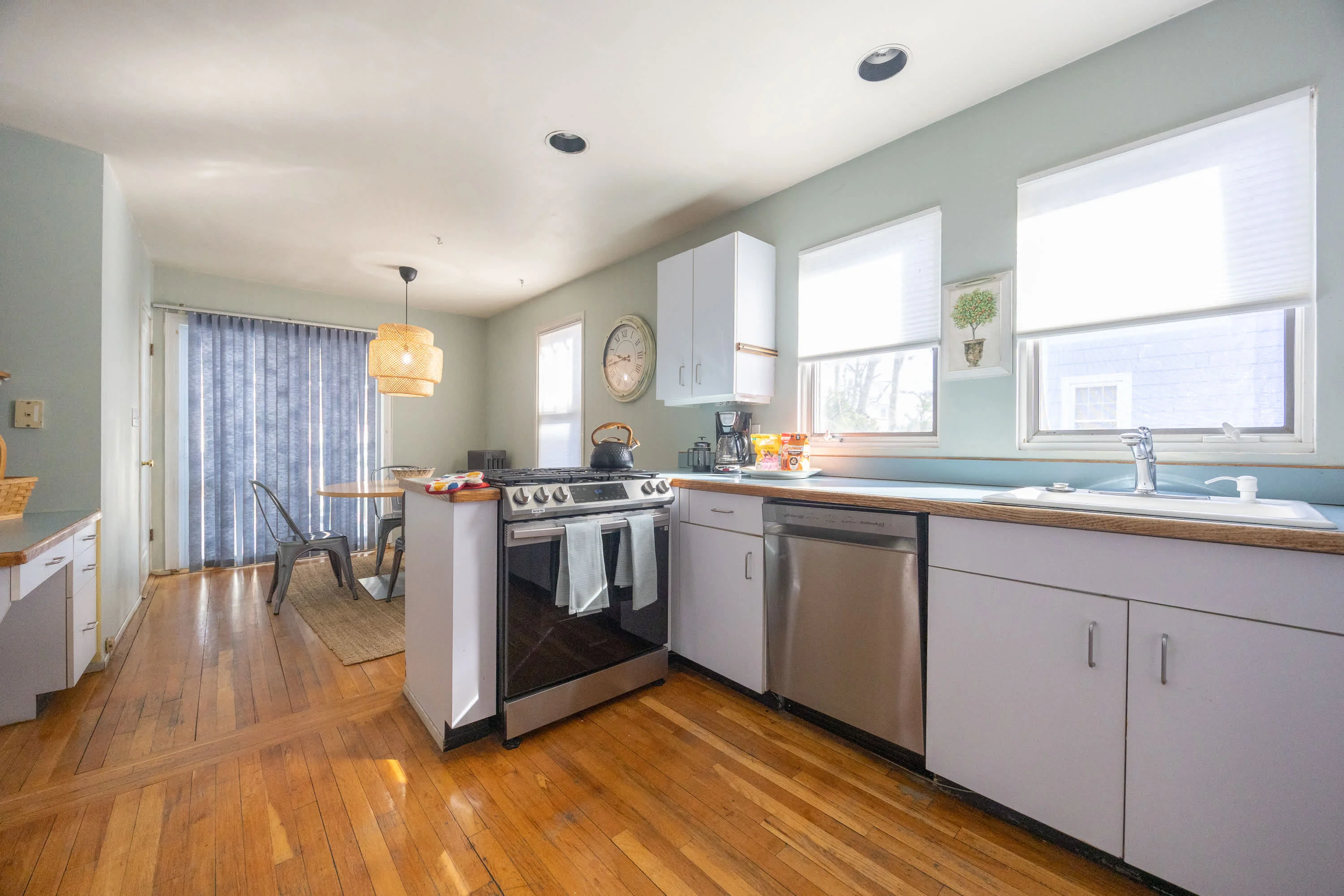 Jamaica Plain rental kitchen with white cabinets and stainless appliances, a base for your Boston itinerary