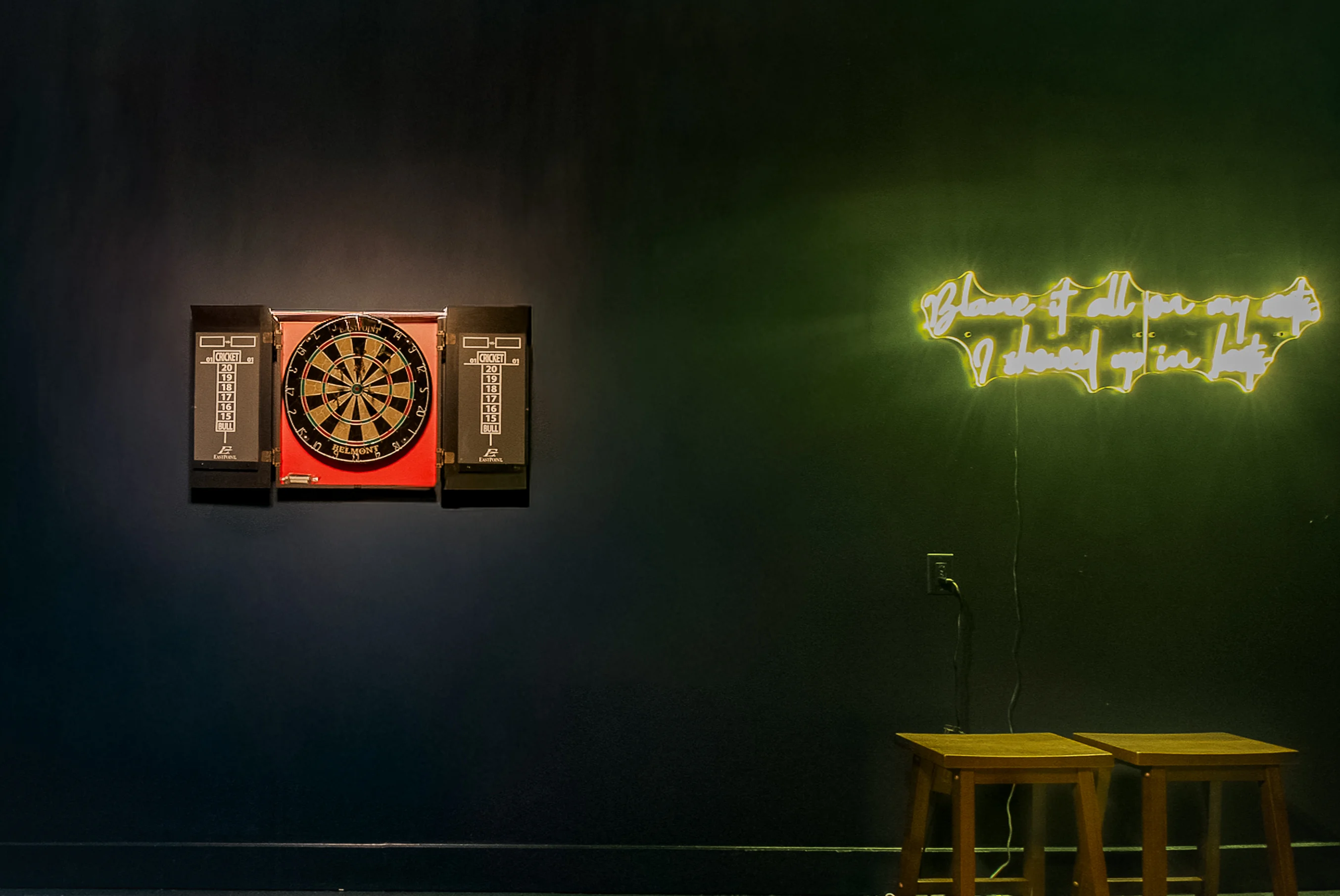 Game room with electronic dartboard and neon sign at short term rental Nashville TN near downtown Broadway district