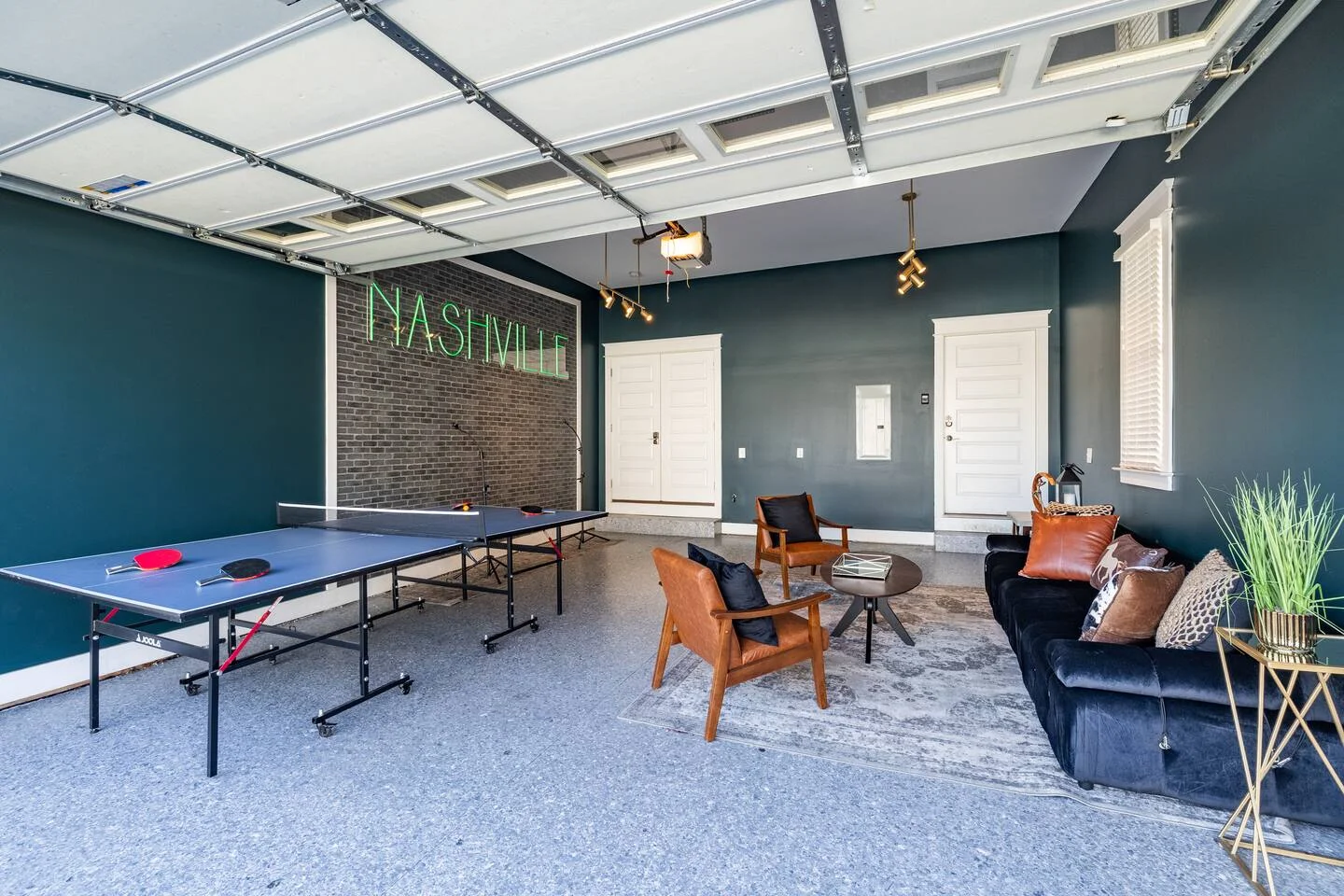 Neon Nashville sign in modern game room with ping-pong table and skylight at Ultimate Bach Pad