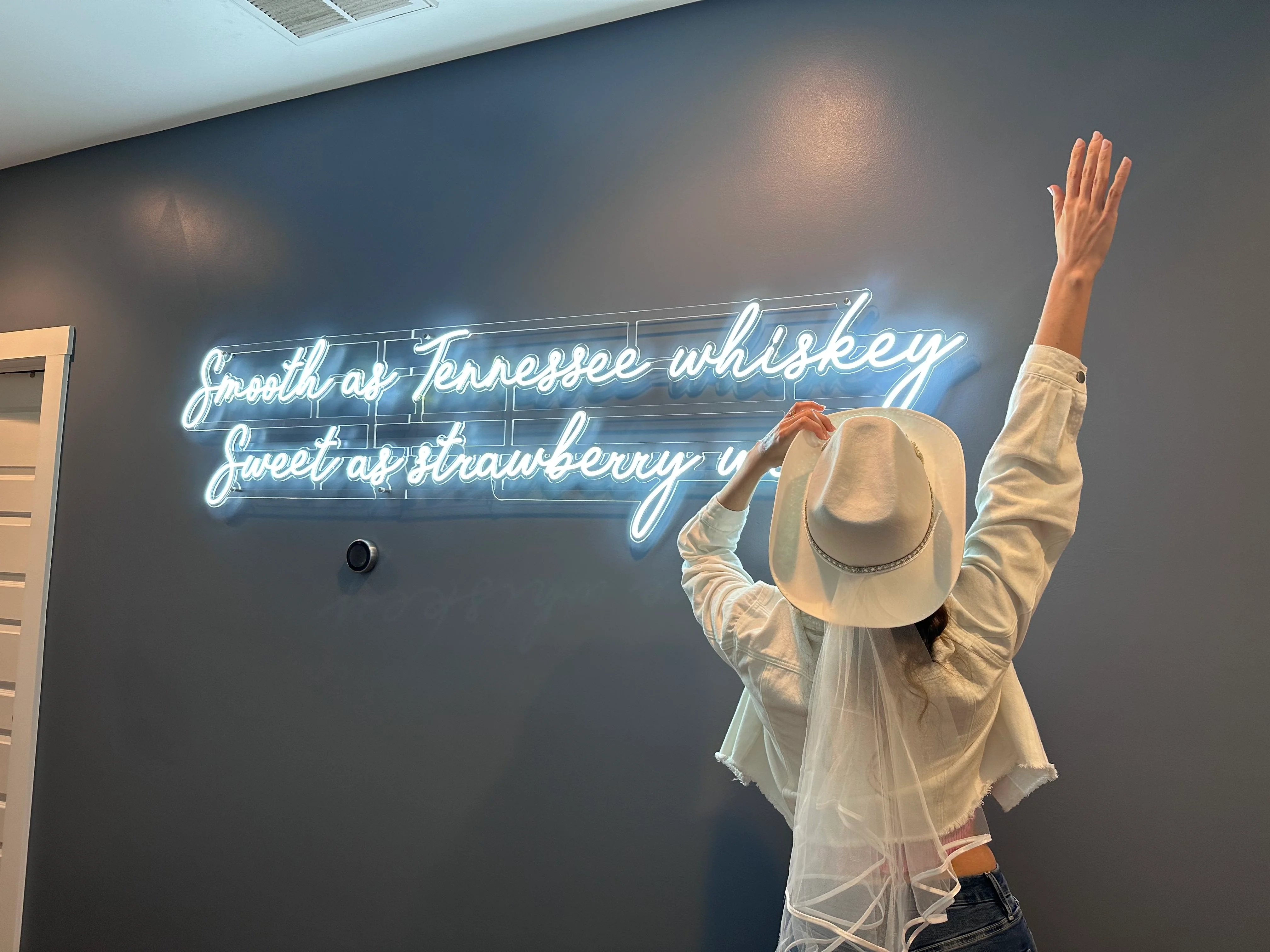 Neon sign reading Smell Tennessee whiskey with western decor in Underwood Manor Nashville entertainment amenity