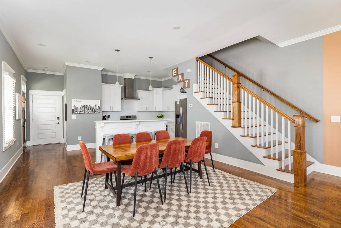 Modern open-concept dining and kitchen with coral chairs in Nashville luxury vacation rental