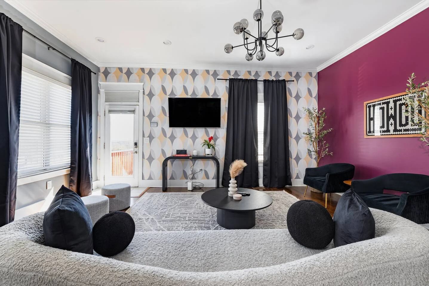 Modern entertainment room with magenta accent wall, geometric wallpaper, TV and bean bag seating for Nashville bachelor