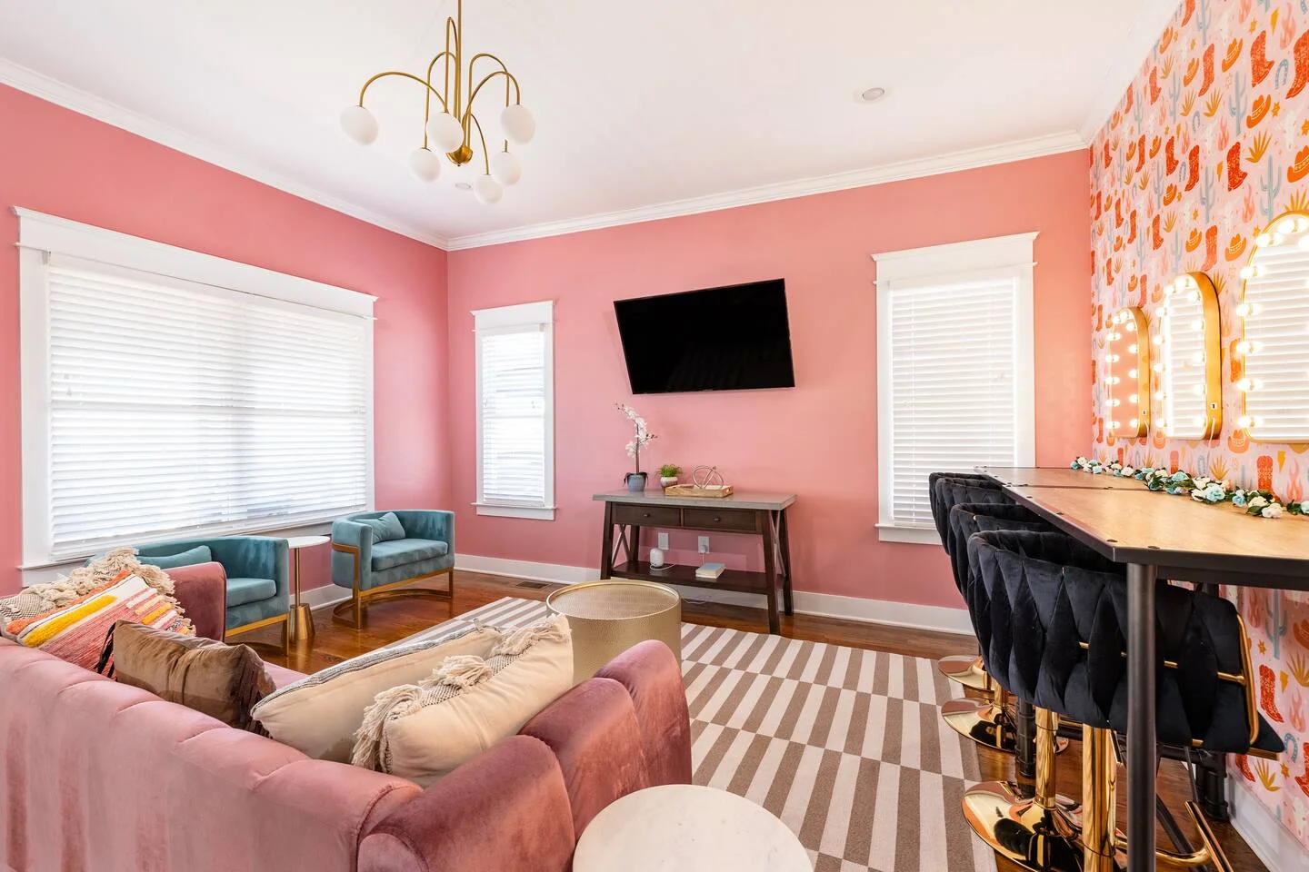Modern pink living room with brass chandelier and contemporary furniture in Nashville group rental