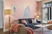 Modern living room with blue-grey sofa and coral throw at Nashville vacation rental for concerts 2026