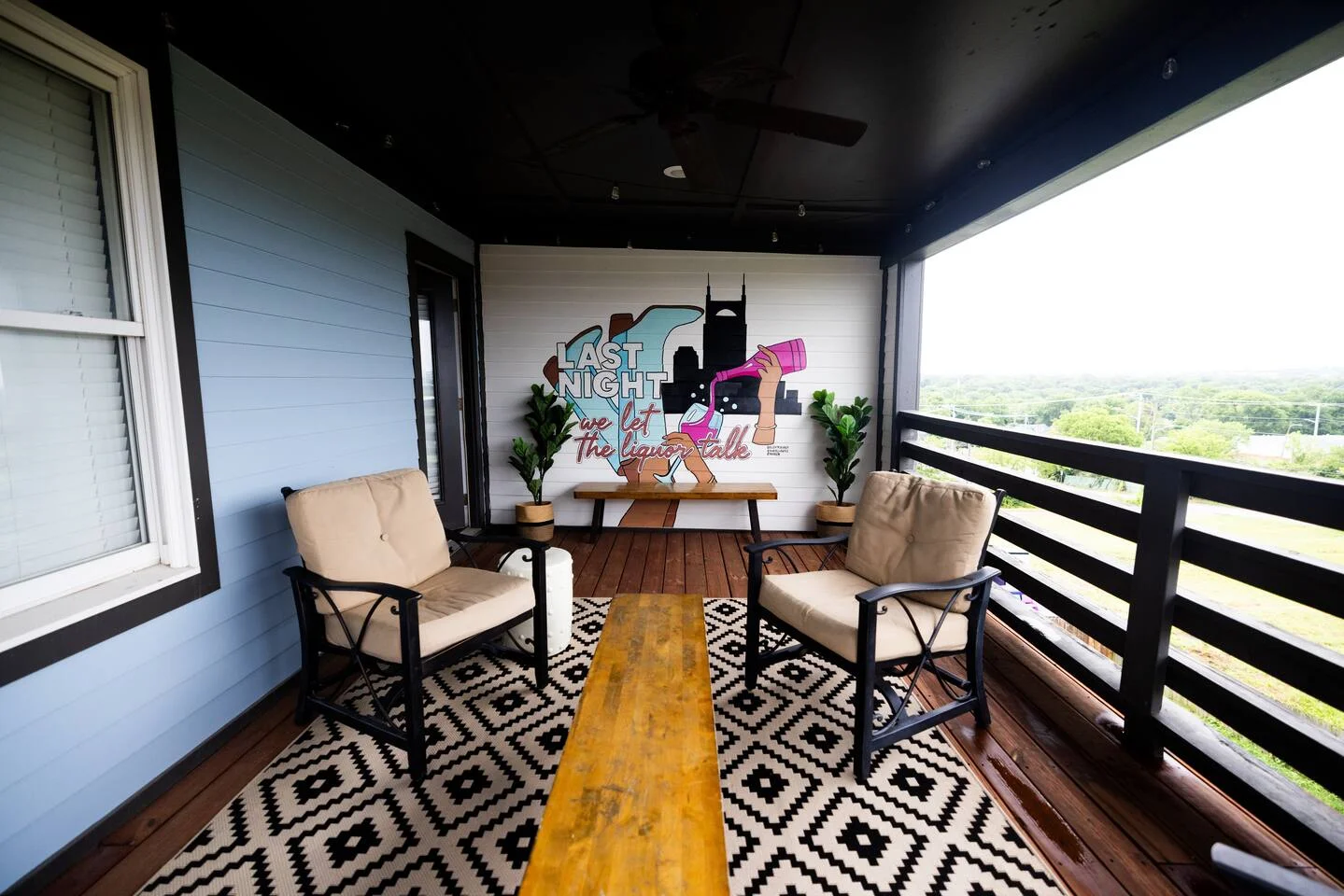 Rooftop patio with lounge chairs and Nashville skyline art mural for bachelorette party planning in Nashville