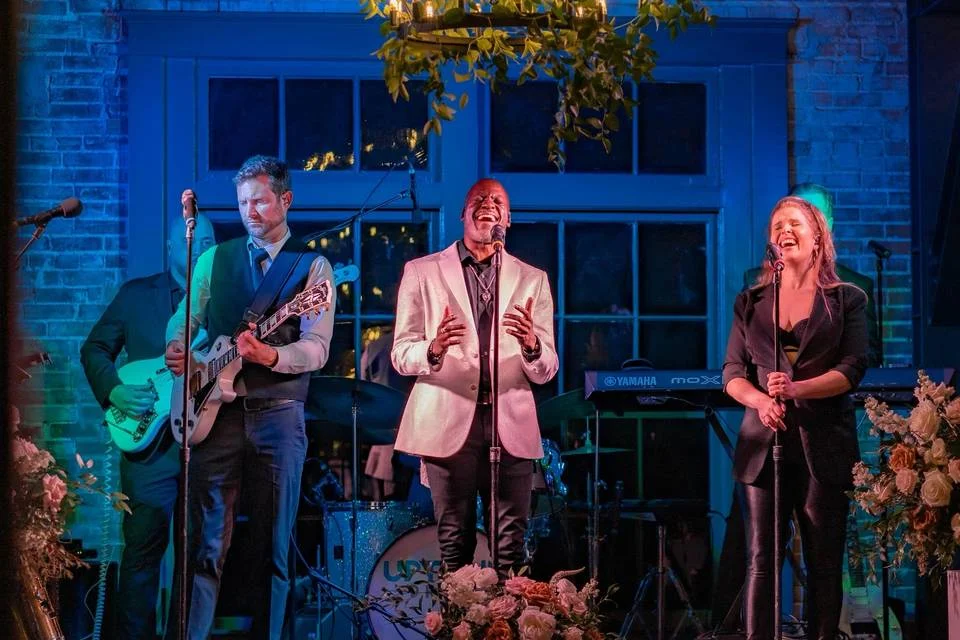 Professional austin cover bands performing with elegant stage lighting and floral decorations