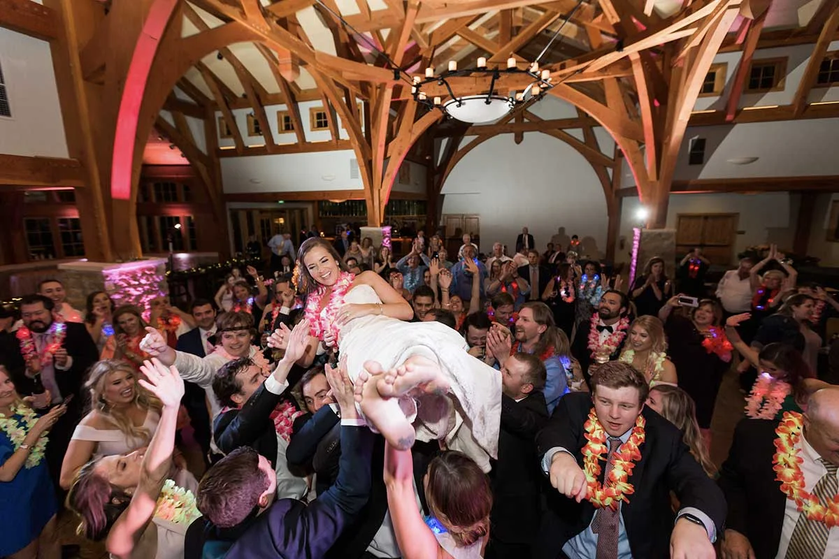 Country first dance songs performed live at rustic wedding reception with wooden beams and romantic lighting
