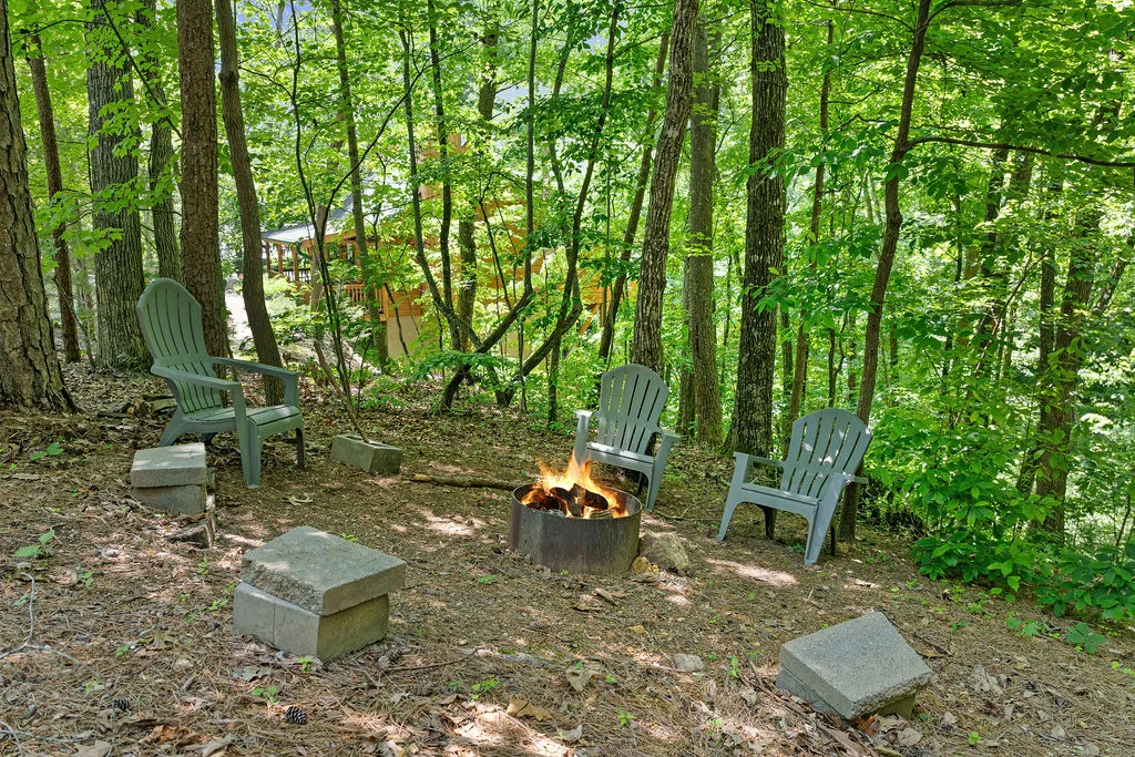 Pet friendly vacation rental fire pit area with Adirondack chairs and forest views in Gatlinburg Tennessee