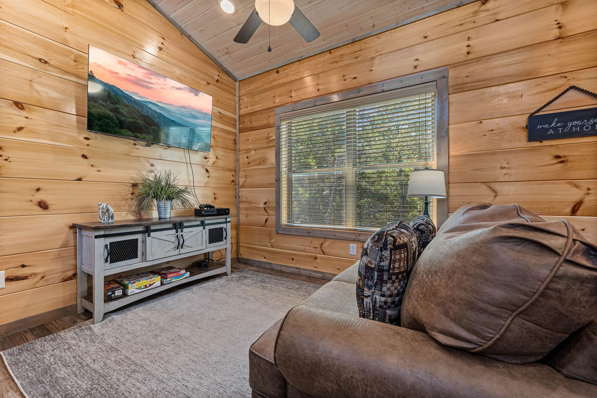 Rustic bedroom in a 2 bedroom cabin Pigeon Forge TN area with leather bed, forest views, and modern cabin finishes