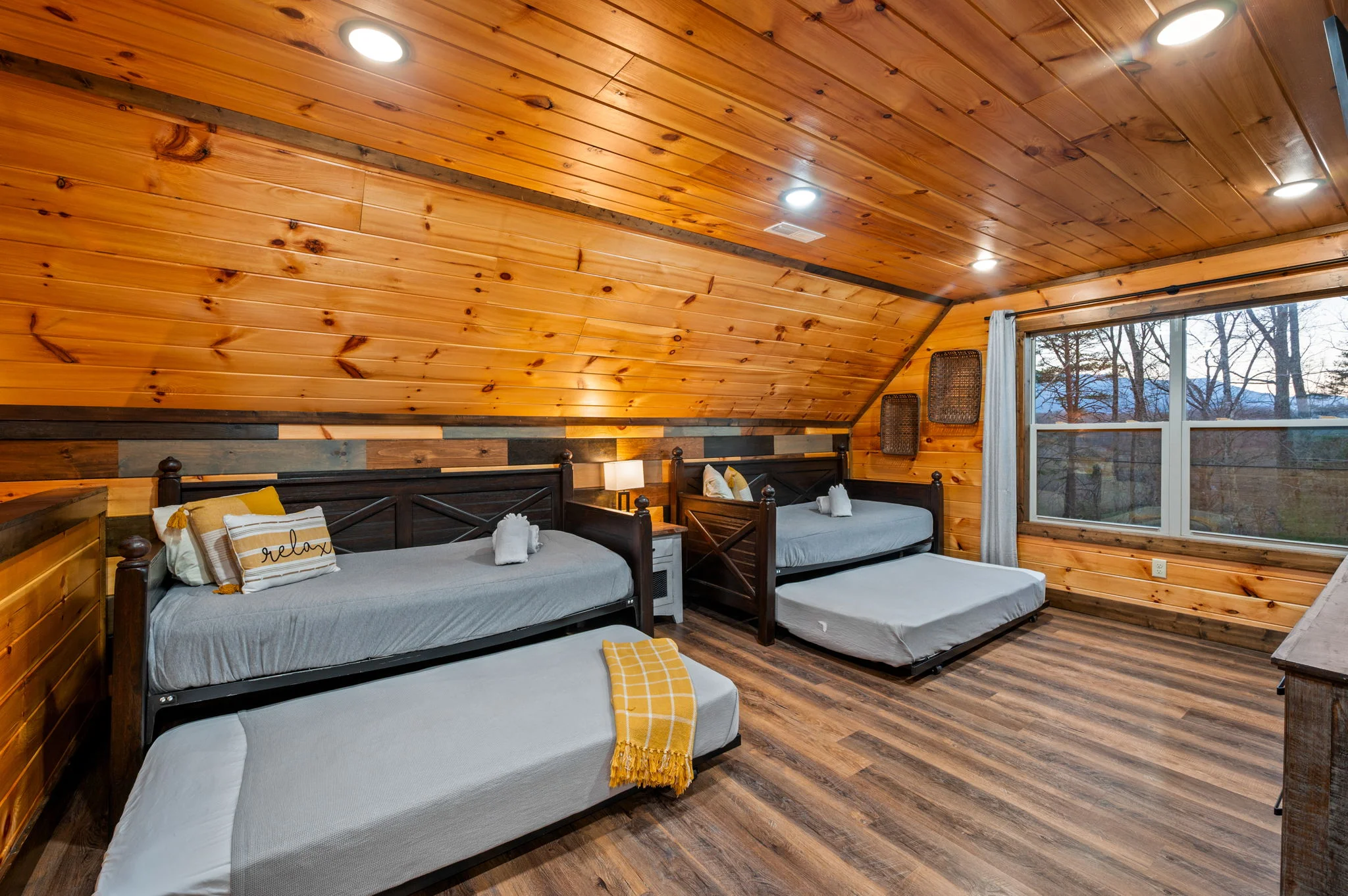 Rustic log cabin bedroom with multiple beds and mountain views, ideal for families at Pigeon Forge Tennessee private indoor