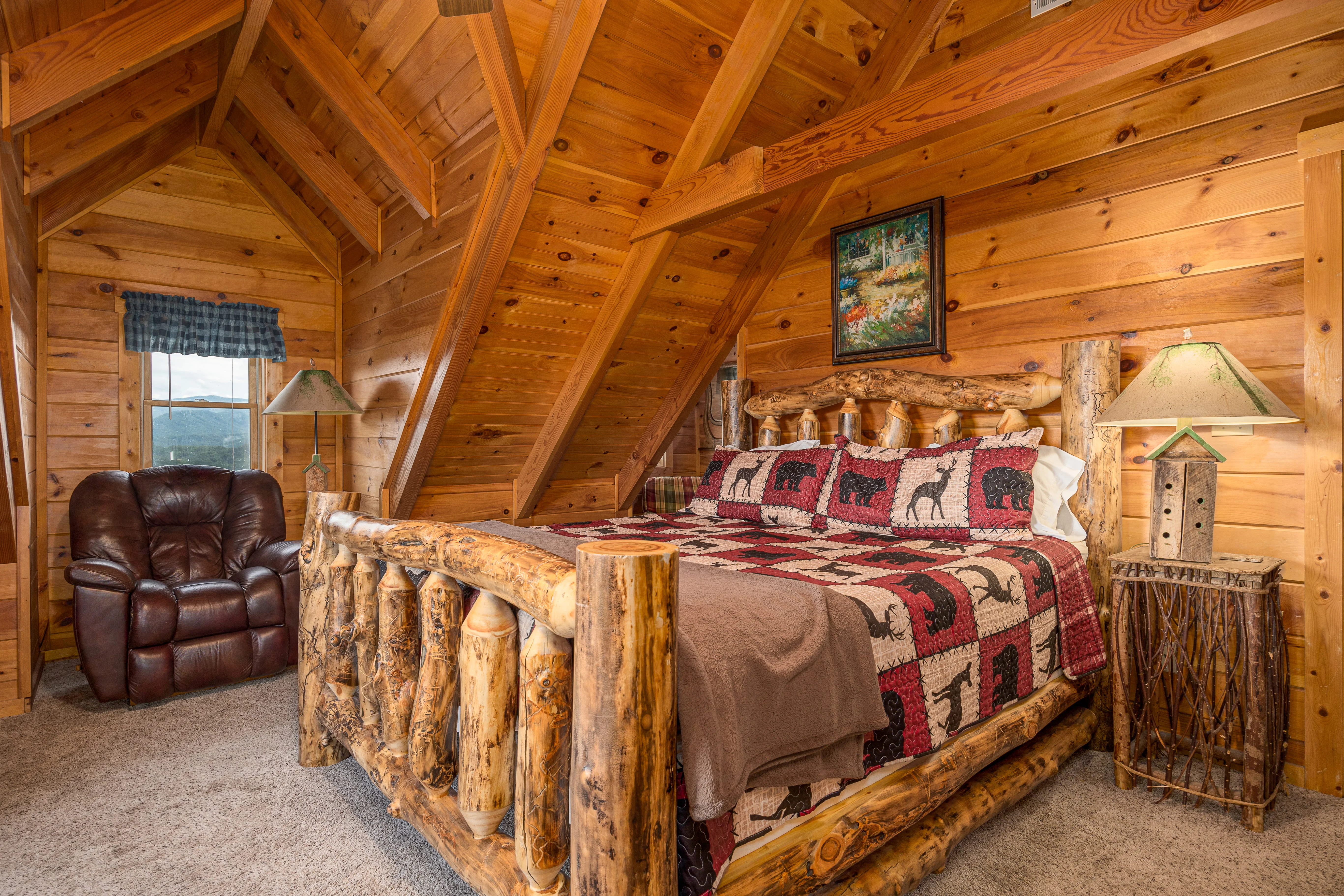 Rustic log cabin bedroom with log bed frame, wildlife bedding, and mountain views from Sevierville TN