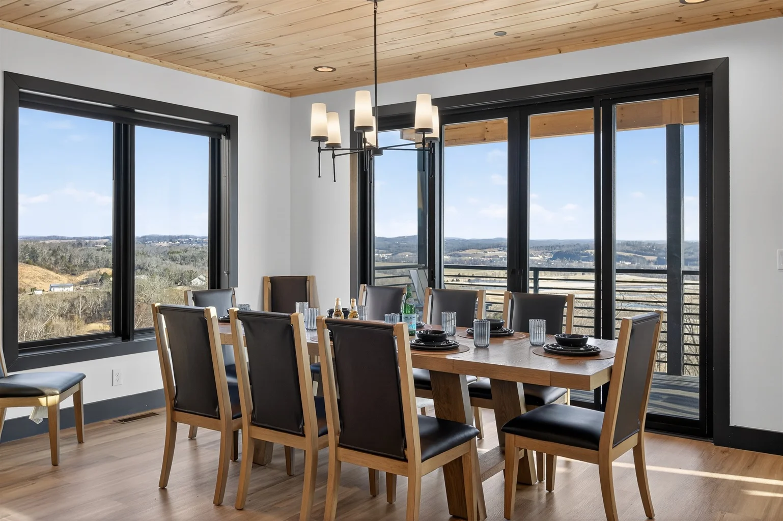 Luxury cabin dining room in Sevierville TN with panoramic mountain valley views through floor-to-ceiling windows and modern