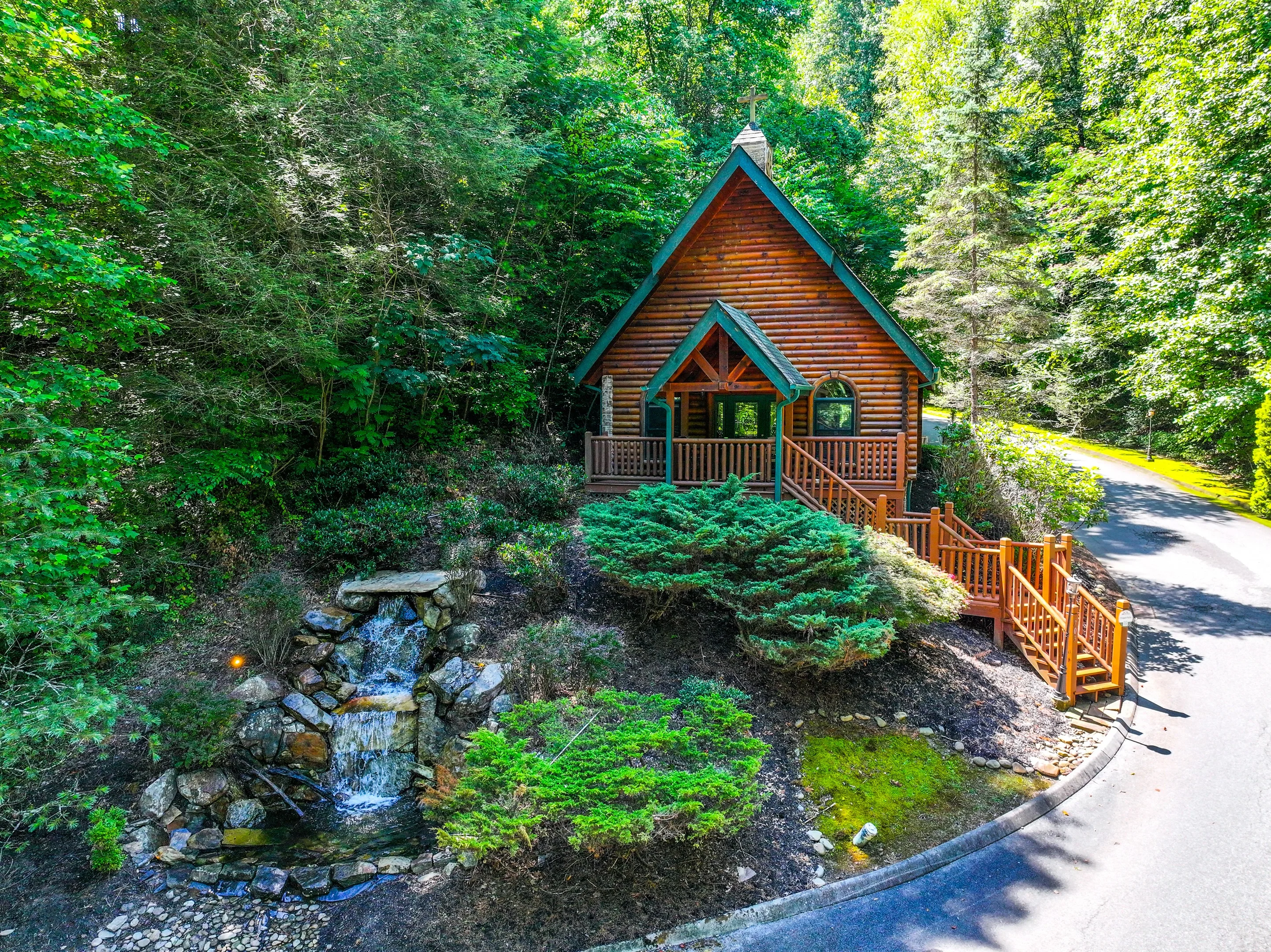 Log cabin with peaked roof and creek in fall foliage forest setting near Gatlinburg