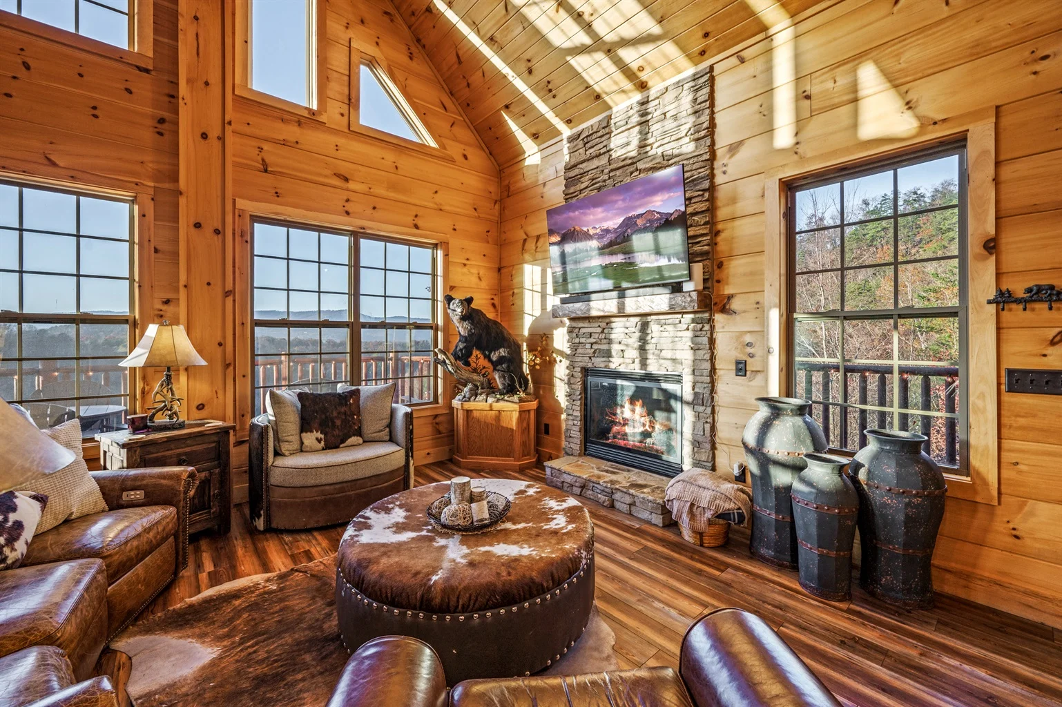 Luxurious log cabin living room with stone fireplace and mountain views in Sevierville TN