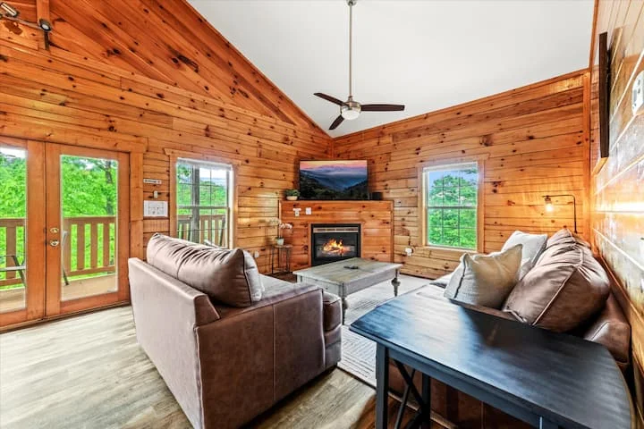 Log cabin living room with stone fireplace for relaxing after Pigeon Forge hiking adventures
