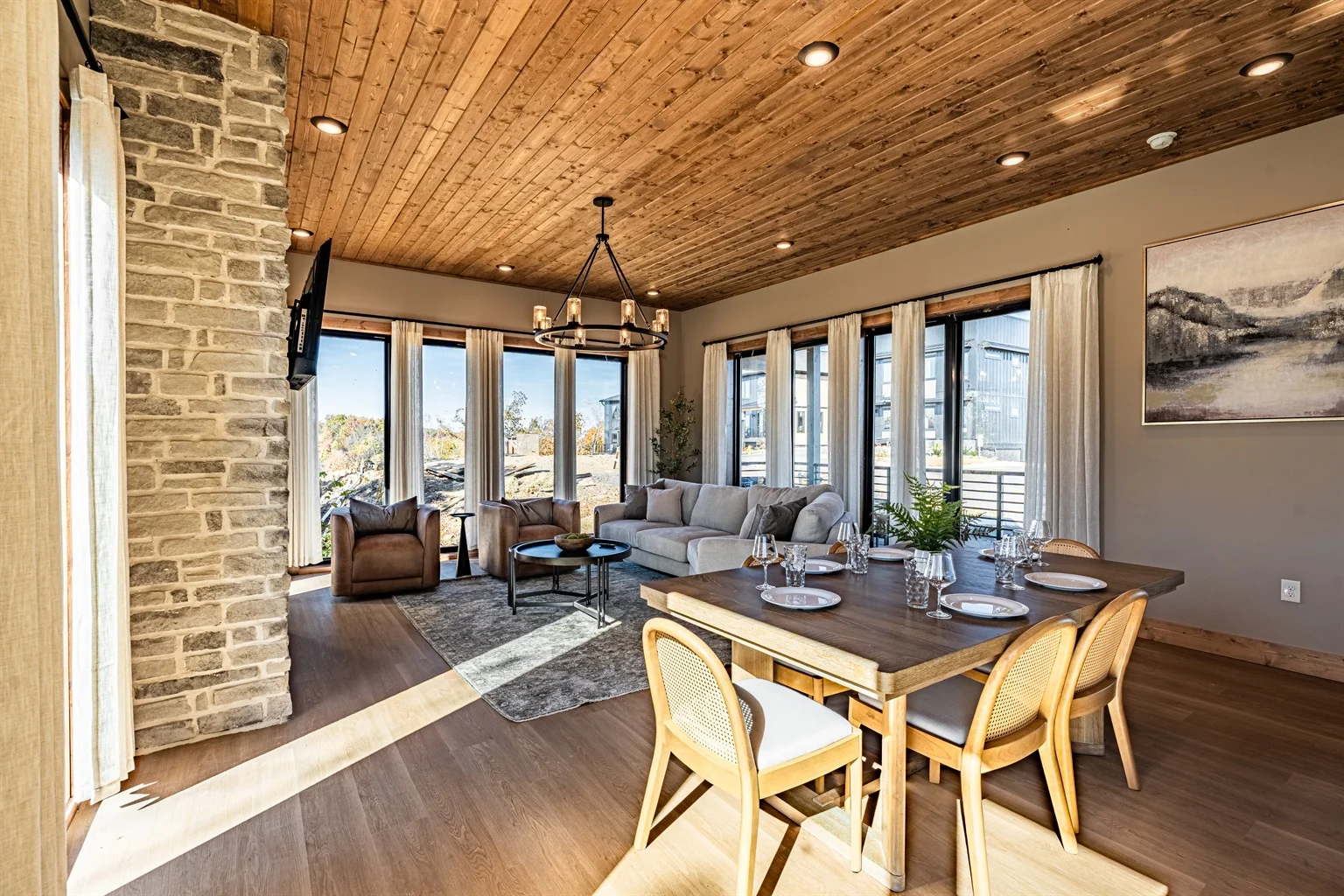 Luxury cabin living room with stone fireplace, wooden ceiling, and mountain views near Gatlinburg TN