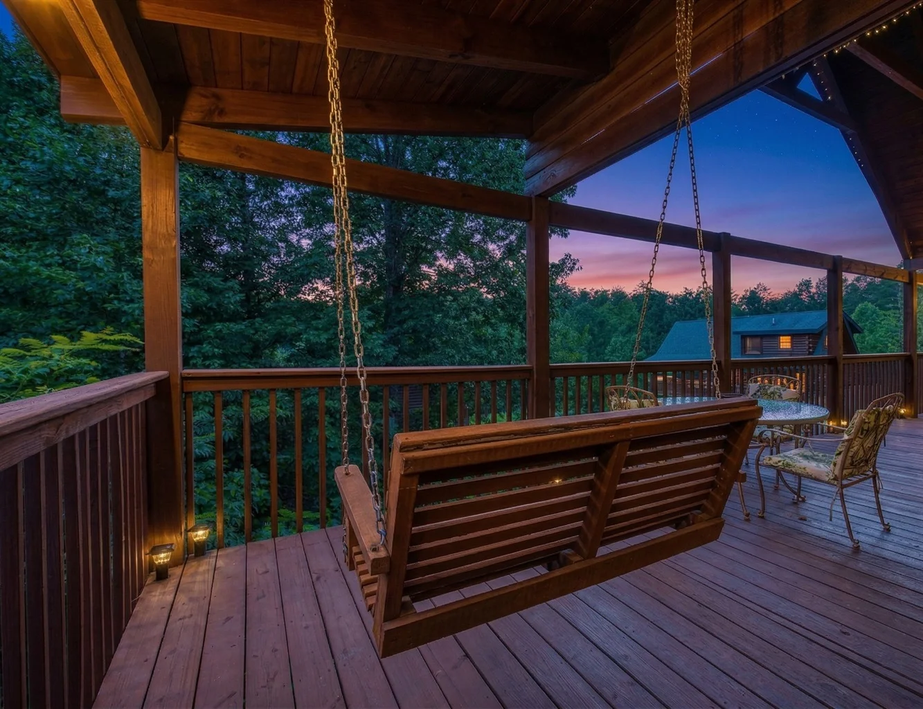 Covered porch with swing overlooking Smoky Mountain sunset, ideal cabin base for Gatlinburg Pigeon Forge Sevierville trips