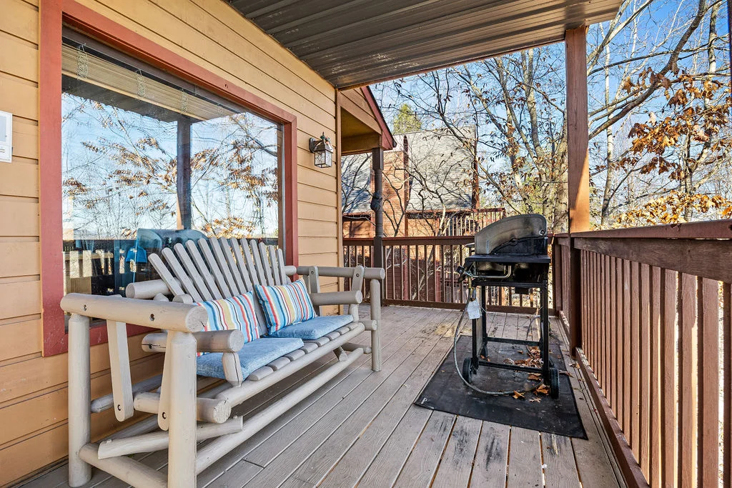 Covered cabin deck with mountain forest views, ideal home base for fine dining in Pigeon Forge TN