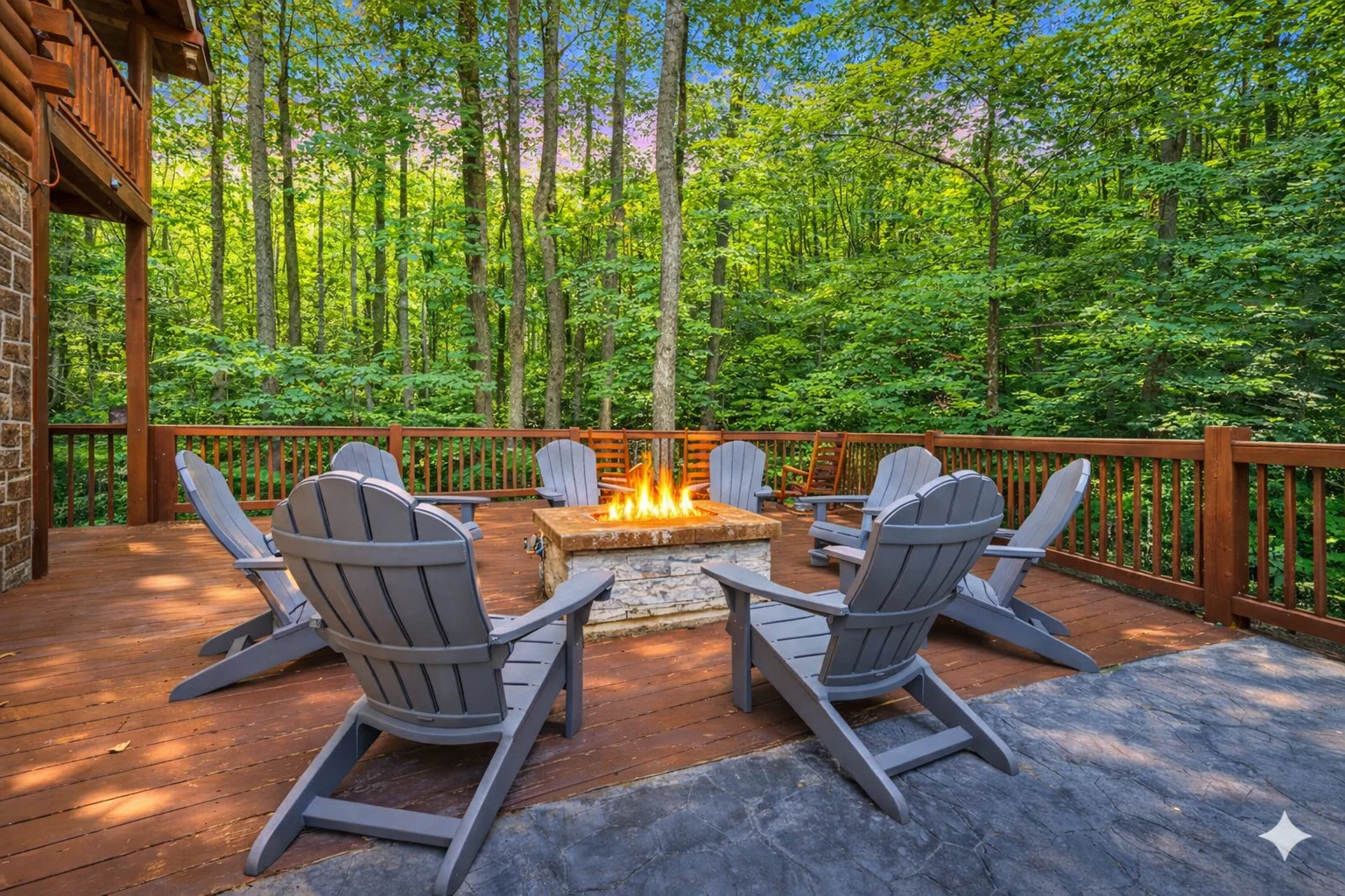 Gray Adirondack chairs surround a stone fire pit on a wooden deck at luxury romantic cabin interior getaway near Sevierville