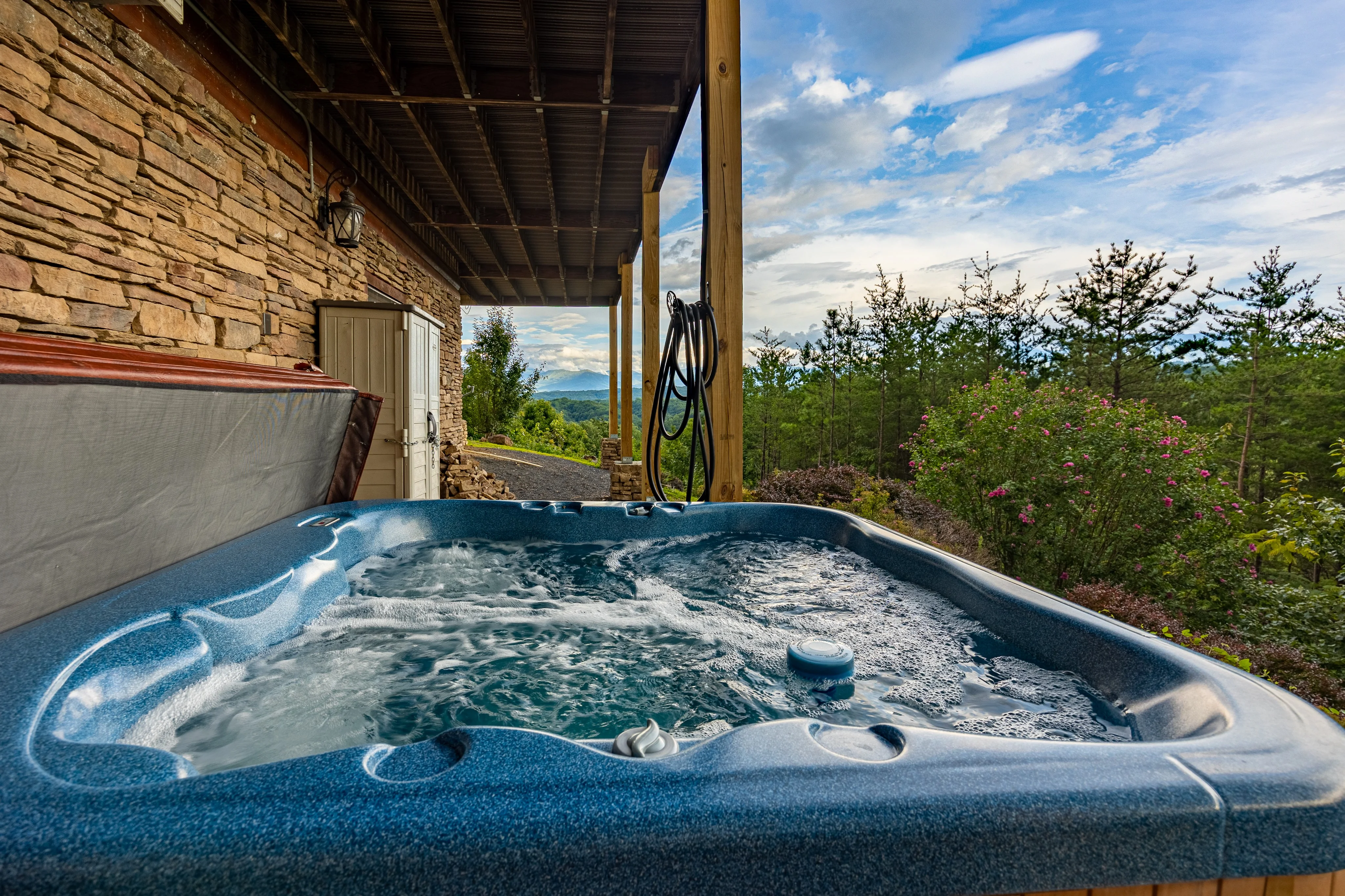 Hot tub on covered patio with panoramic mountain views, perfect home base for Alum Cave Trail hikers in the Smokies