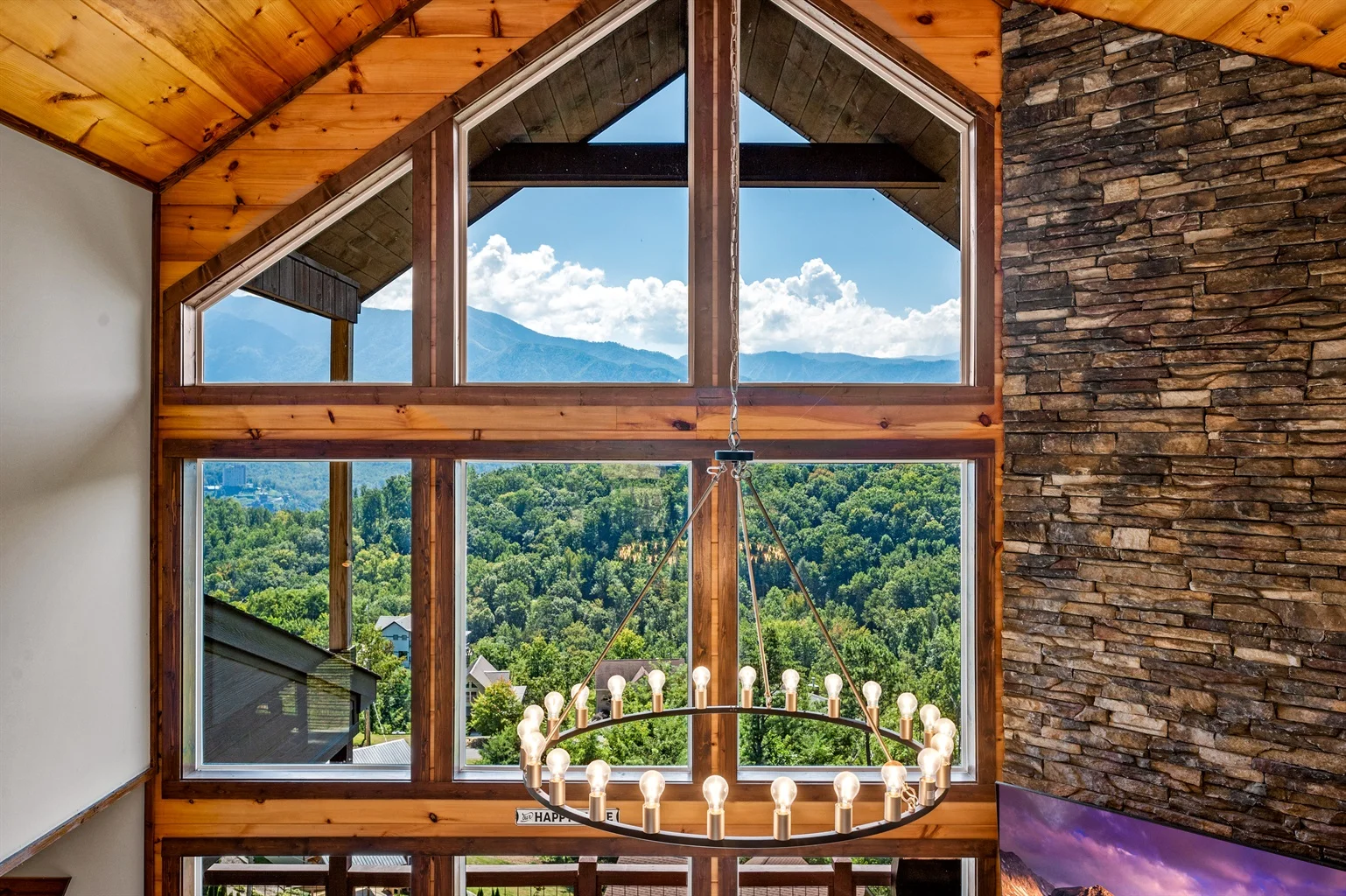 Floor-to-ceiling windows frame Smoky Mountains views at best vacation rentals in Gatlinburg Tennessee with rustic wood beams