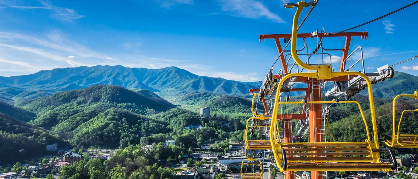 Aerial view of Smoky Mountains ski lift above lush valley forests near Pigeon Forge TN, showing scenic mountain landscape