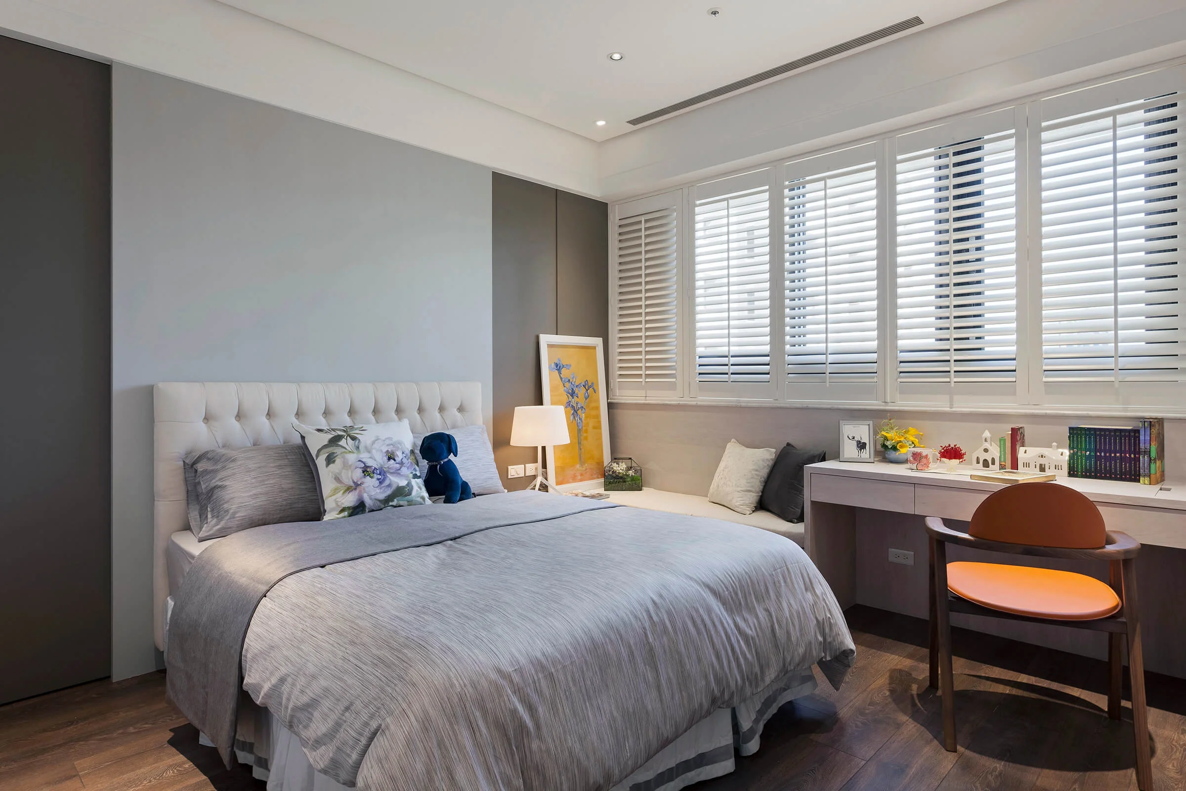 Modern bedroom with white plantation shutters showing moisture-resistant window treatments and natural light filtering